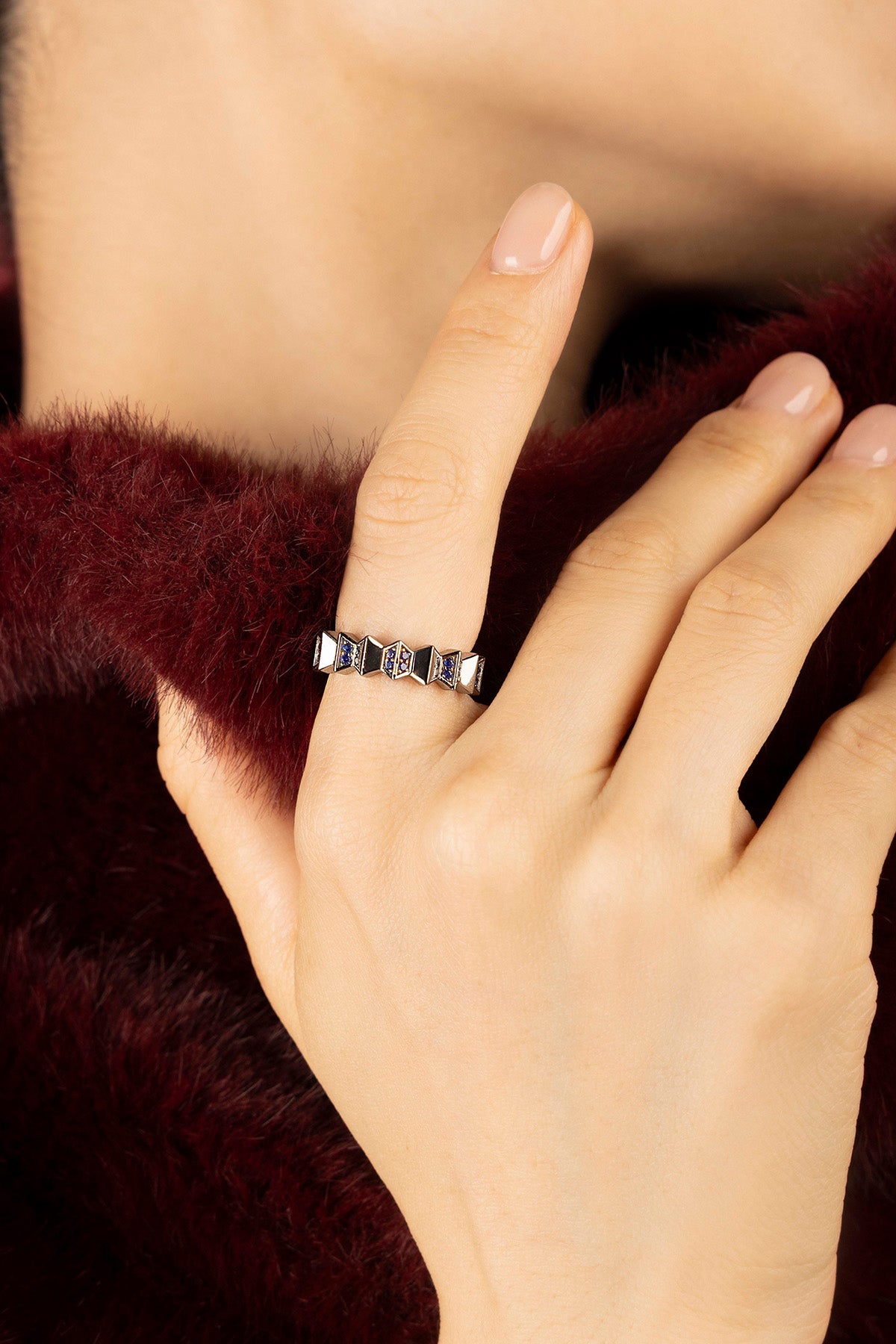 Woman wearing APM Morse Ring, a geometric whisper in rhodium finish and deep blue.