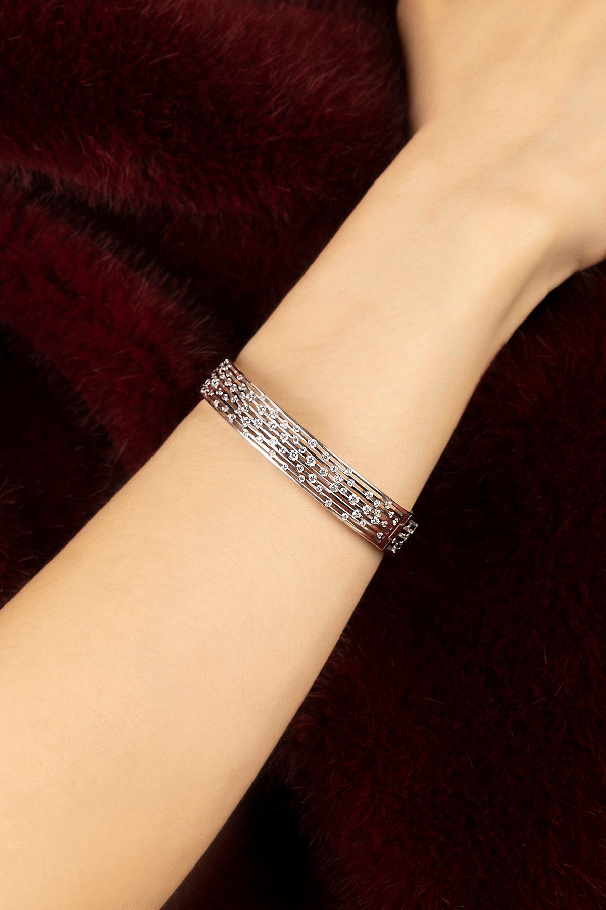 Woman wearing APM bracelet, a shimmering cascade of light on winter velvet.