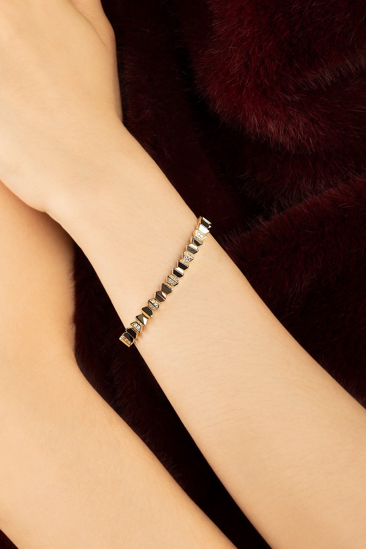 Woman wearing APM bracelet, geometric edge and golden allure for a bold statement.