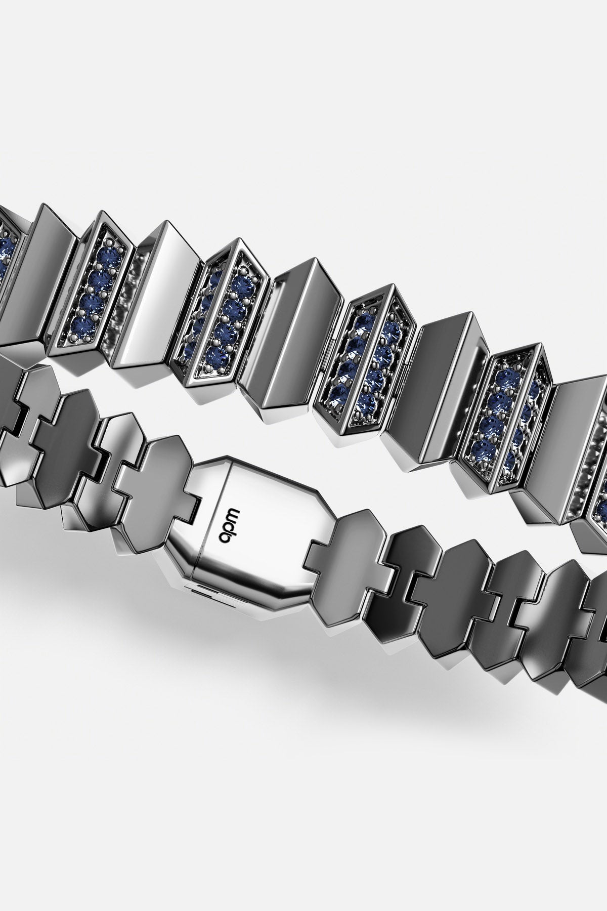 Man wearing APM Monaco bracelet, bold architectural links with deep blue stones, quietly powerful.