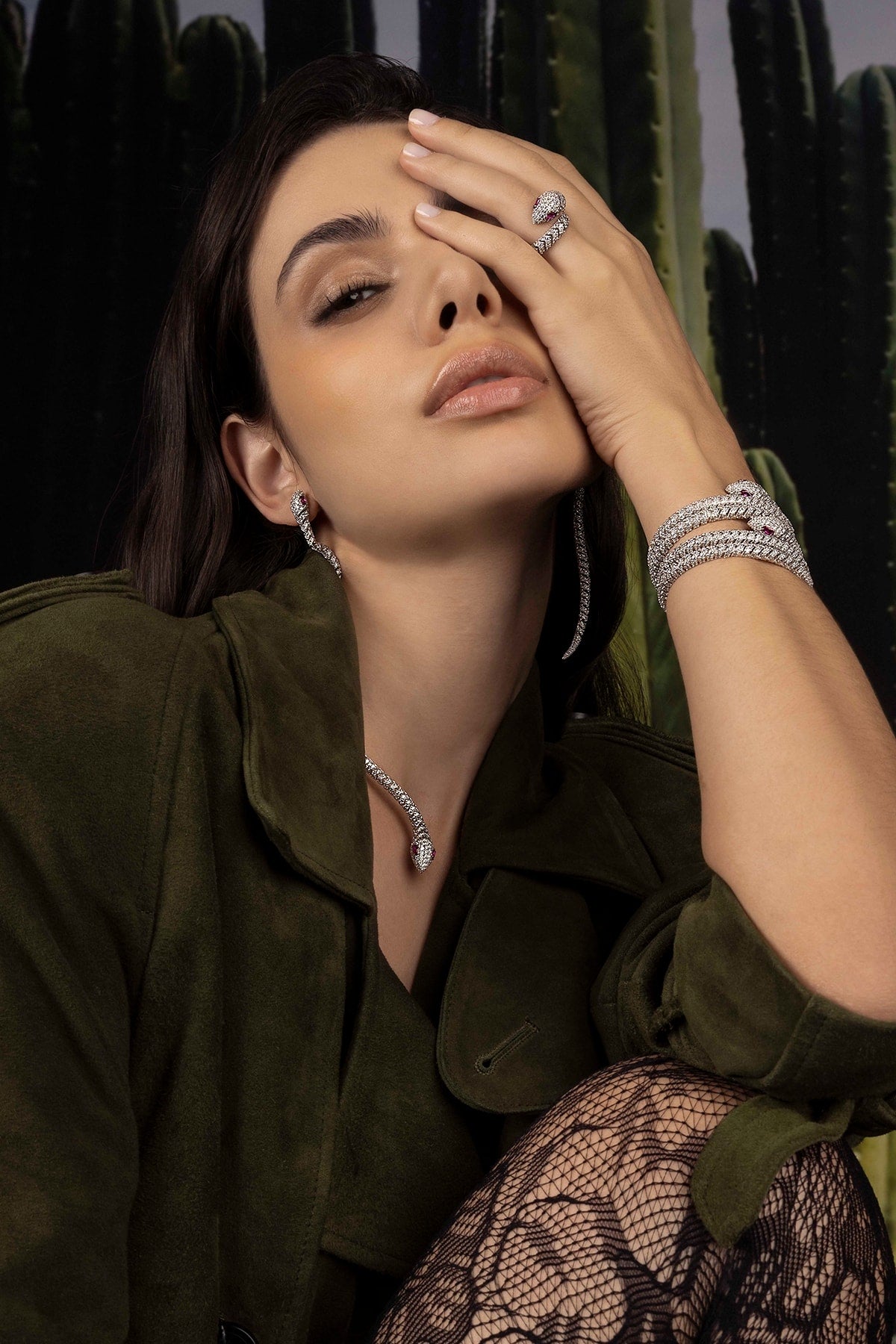 Woman wearing jewelry with a cactus plant in the background