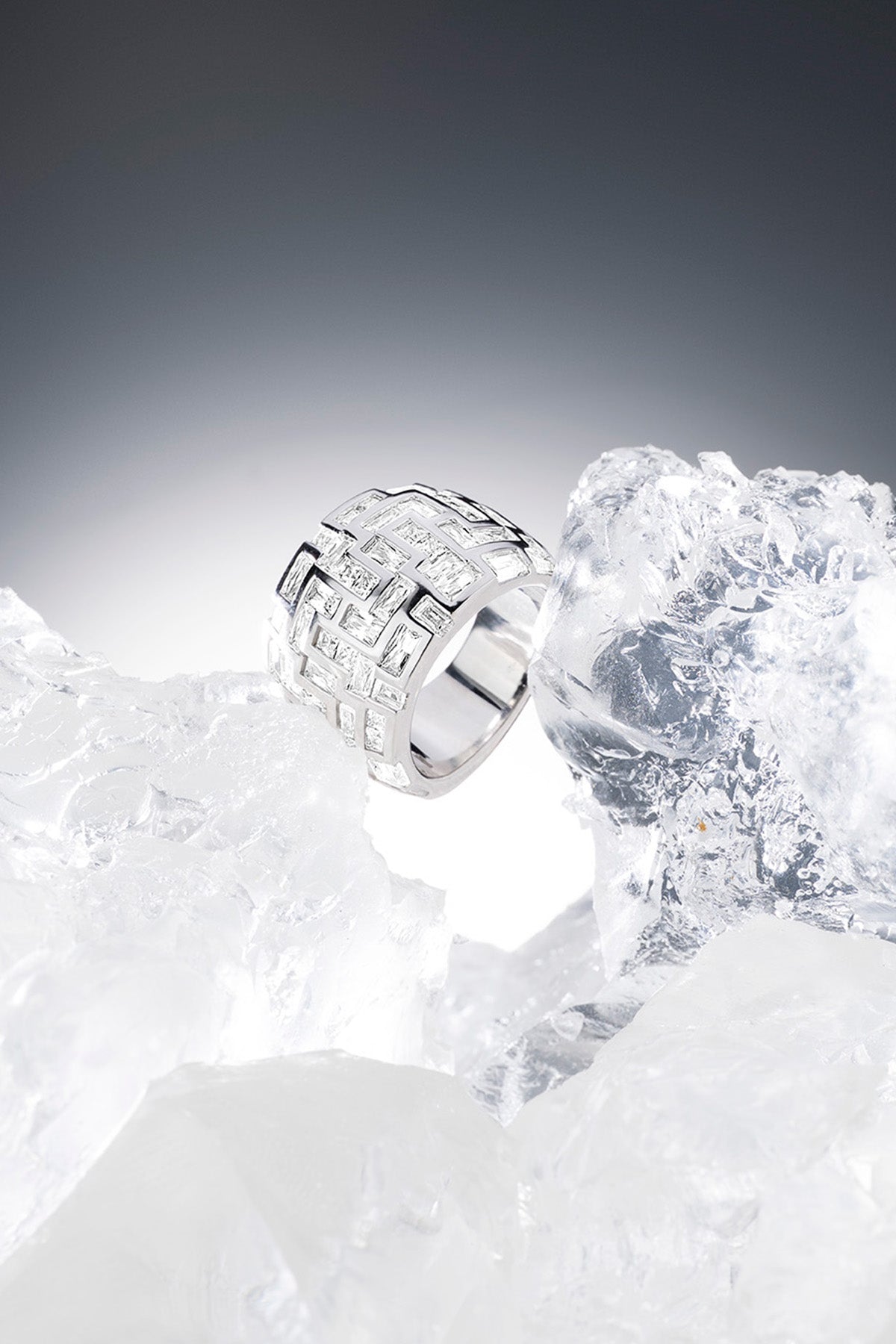 APM MONACO chunky labyrinth ring in silver on a textured iced surface