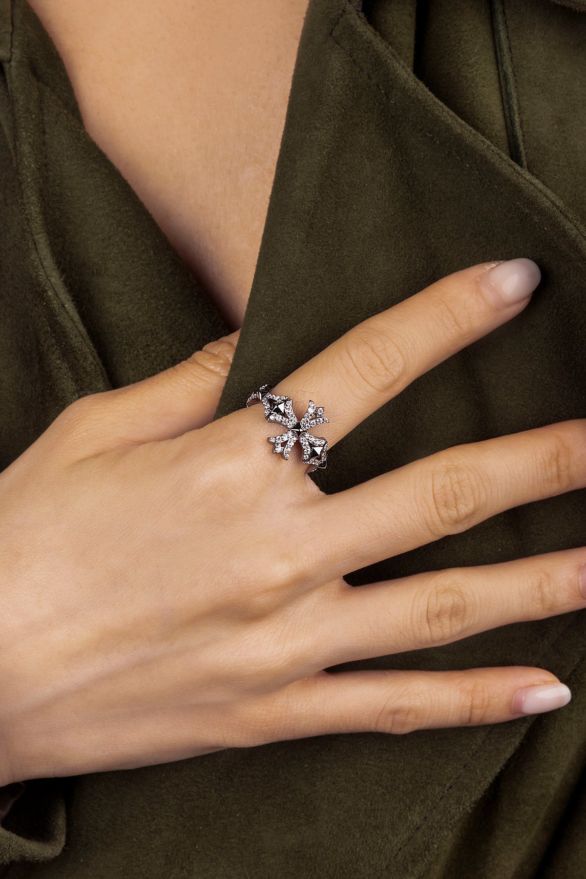 Hand wearing a APM Monaco Cross Ring in dark grey