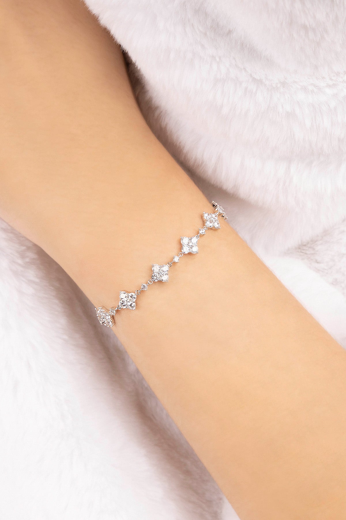 APM MONACO spark adjustable bracelet in silver on a person's wrist against a soft white background