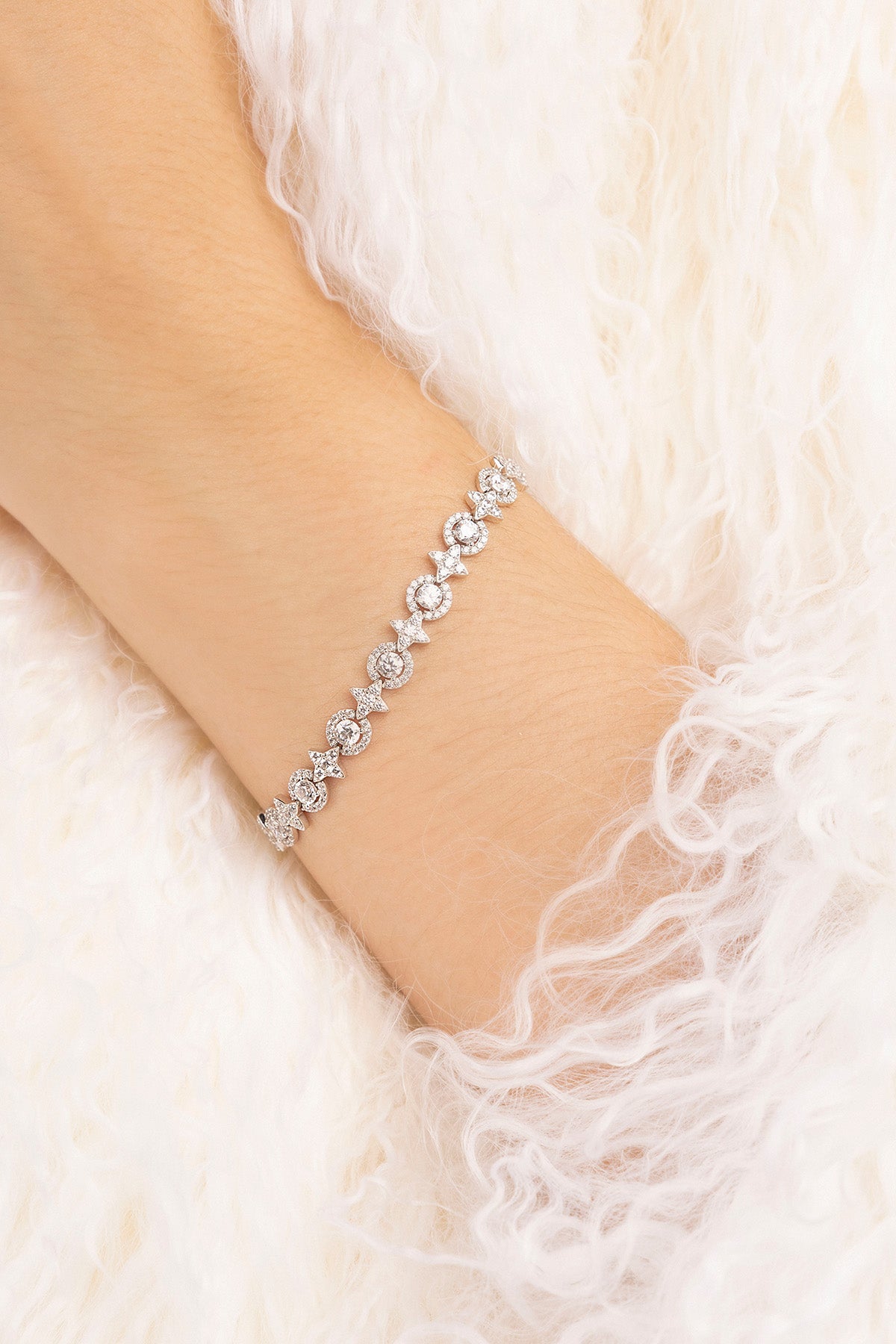 Silver bracelet on a wrist with a soft white background