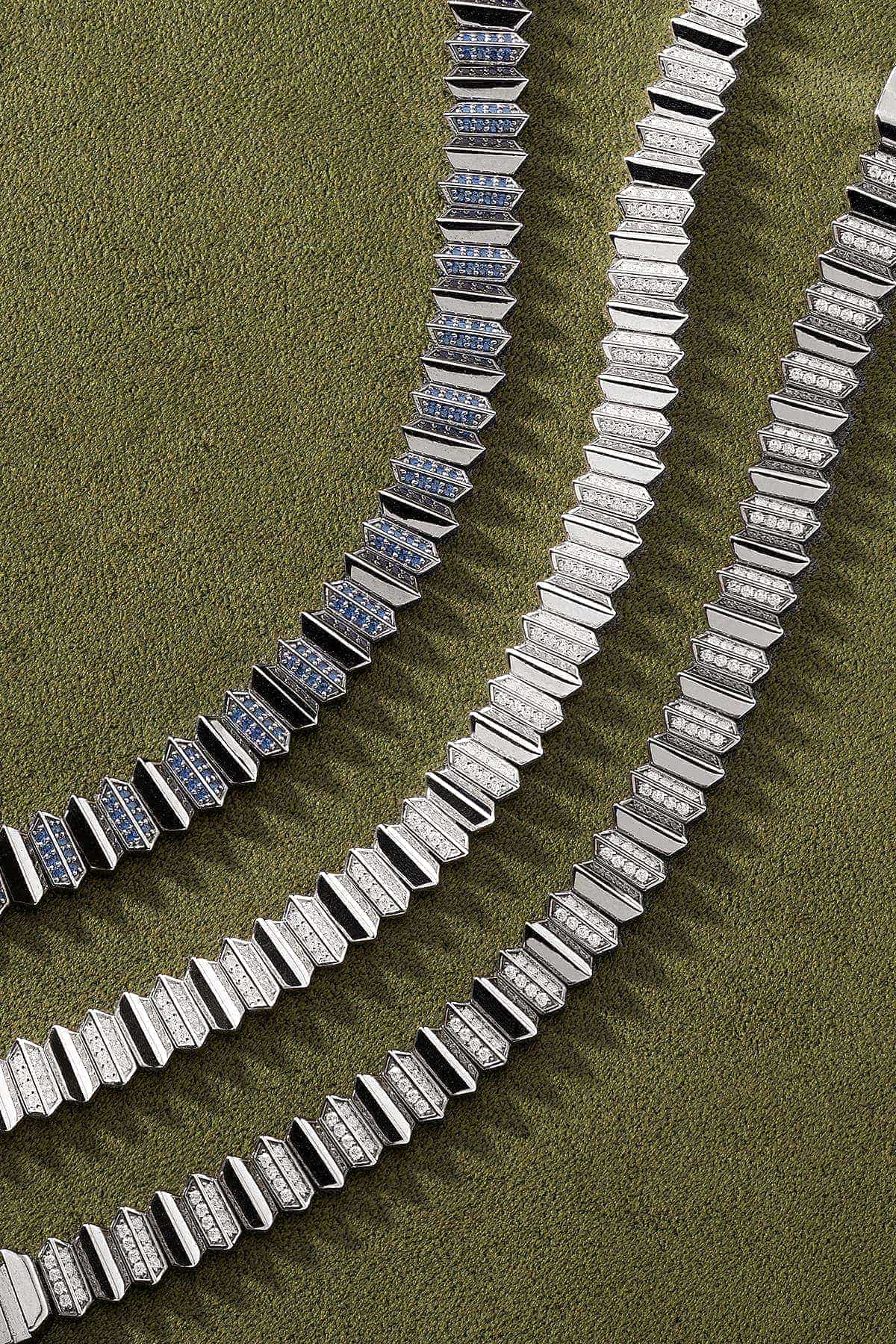 Silver bracelets on a textured green surface