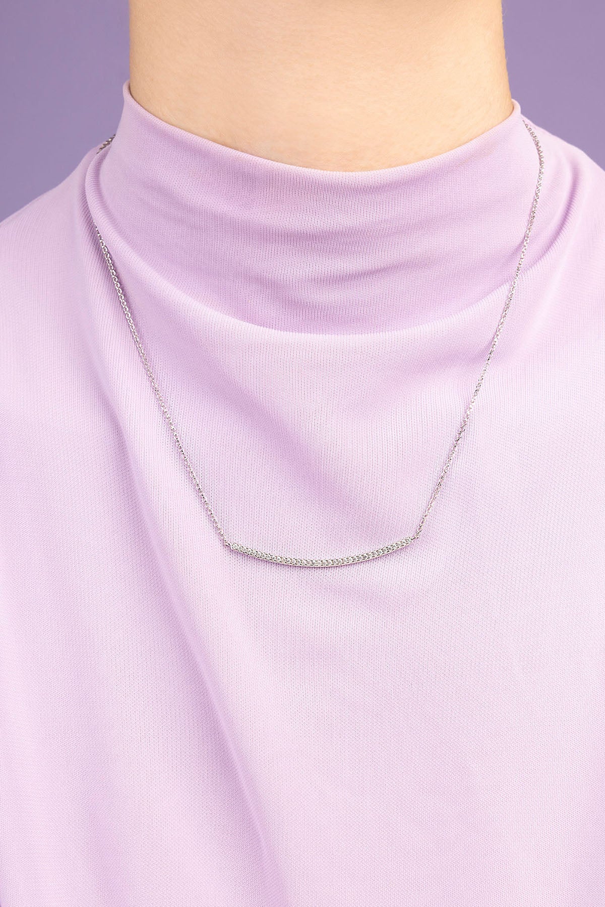 APM Monaco adjustable necklace wearing a light purple top against a purple background