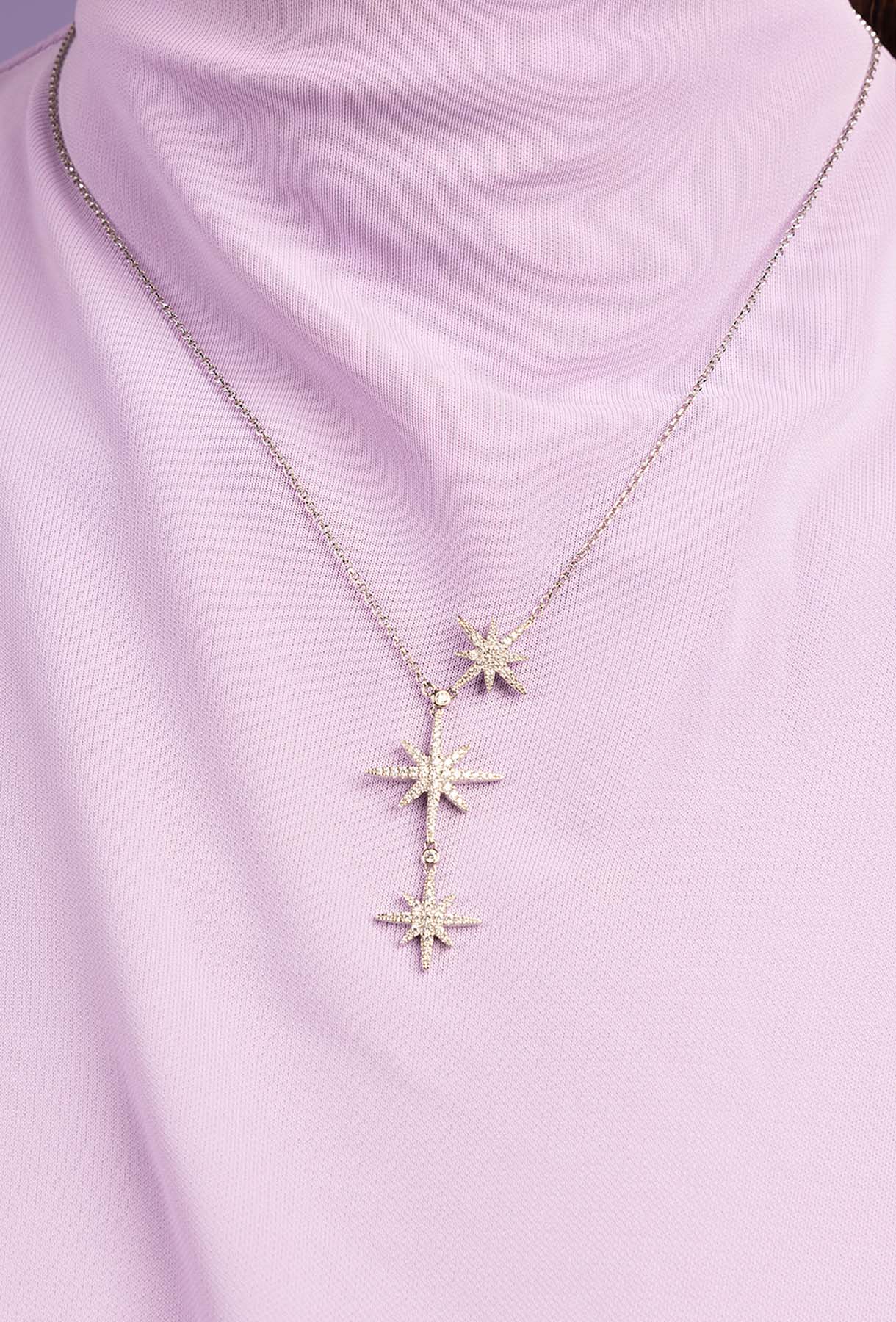 Necklace with star-shaped pendants on a light purple background