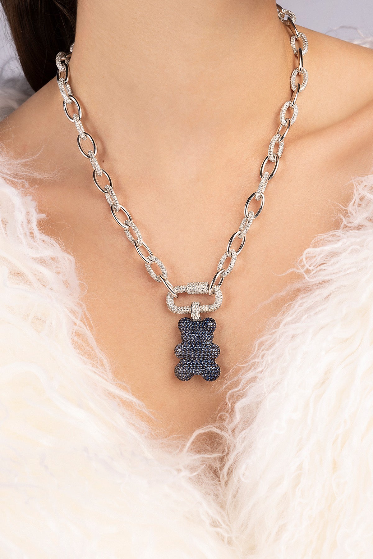 Silver chain necklace from APM MONACO with baba yummy bear design pendants worn by a person