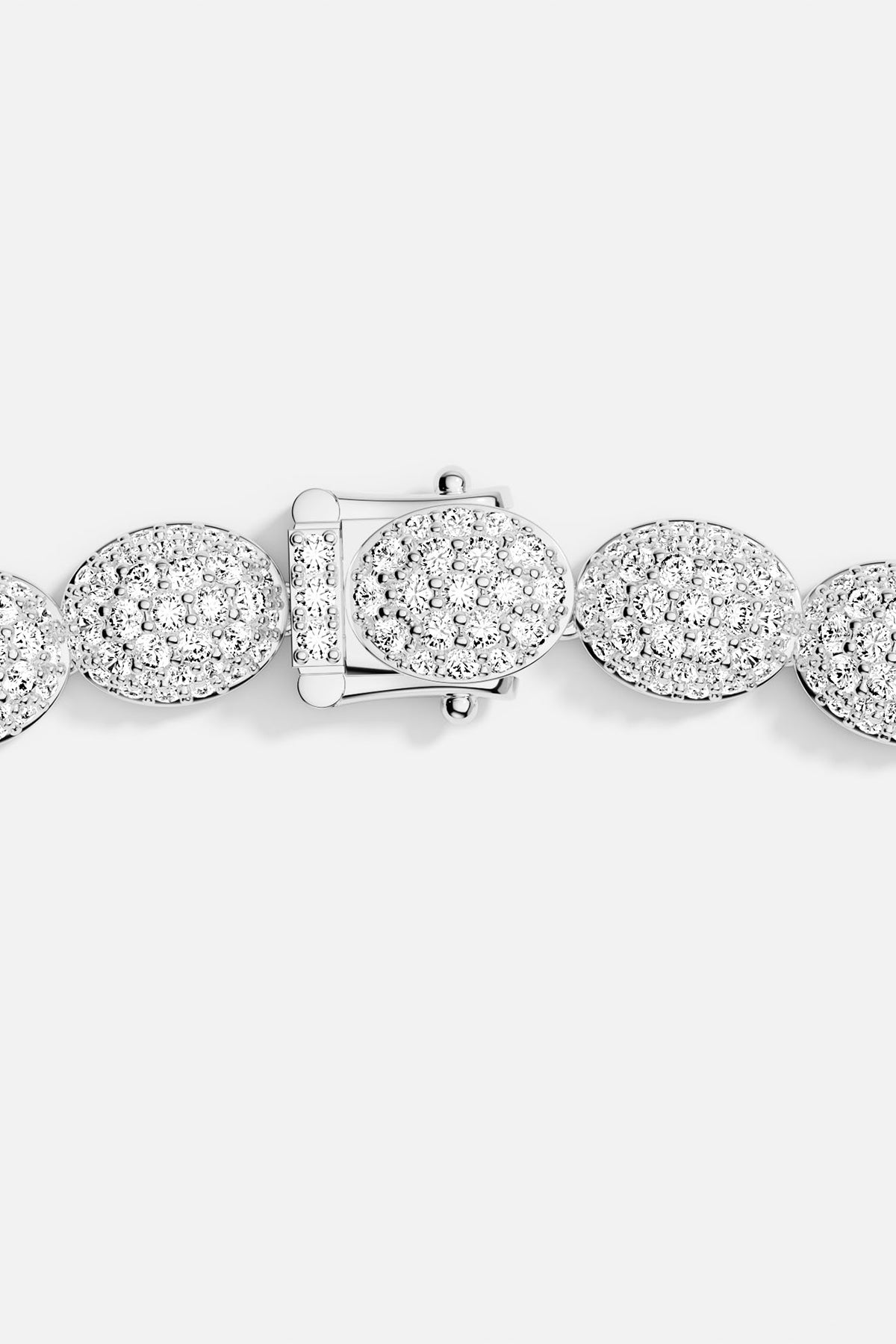 Zoom in of a silver bracelet closing on a grey background