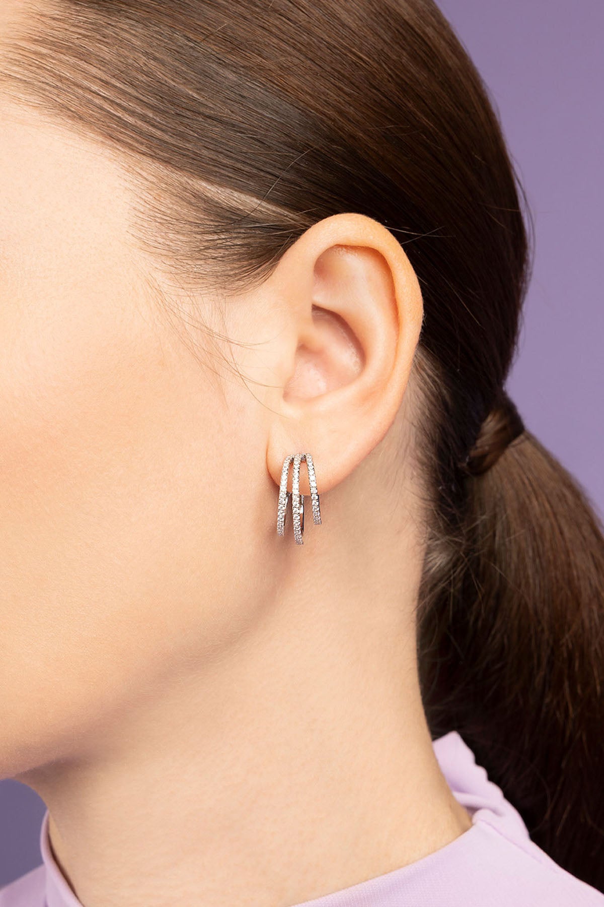 APM Monaco White Triple Hoop Earring worn on model with lilac background