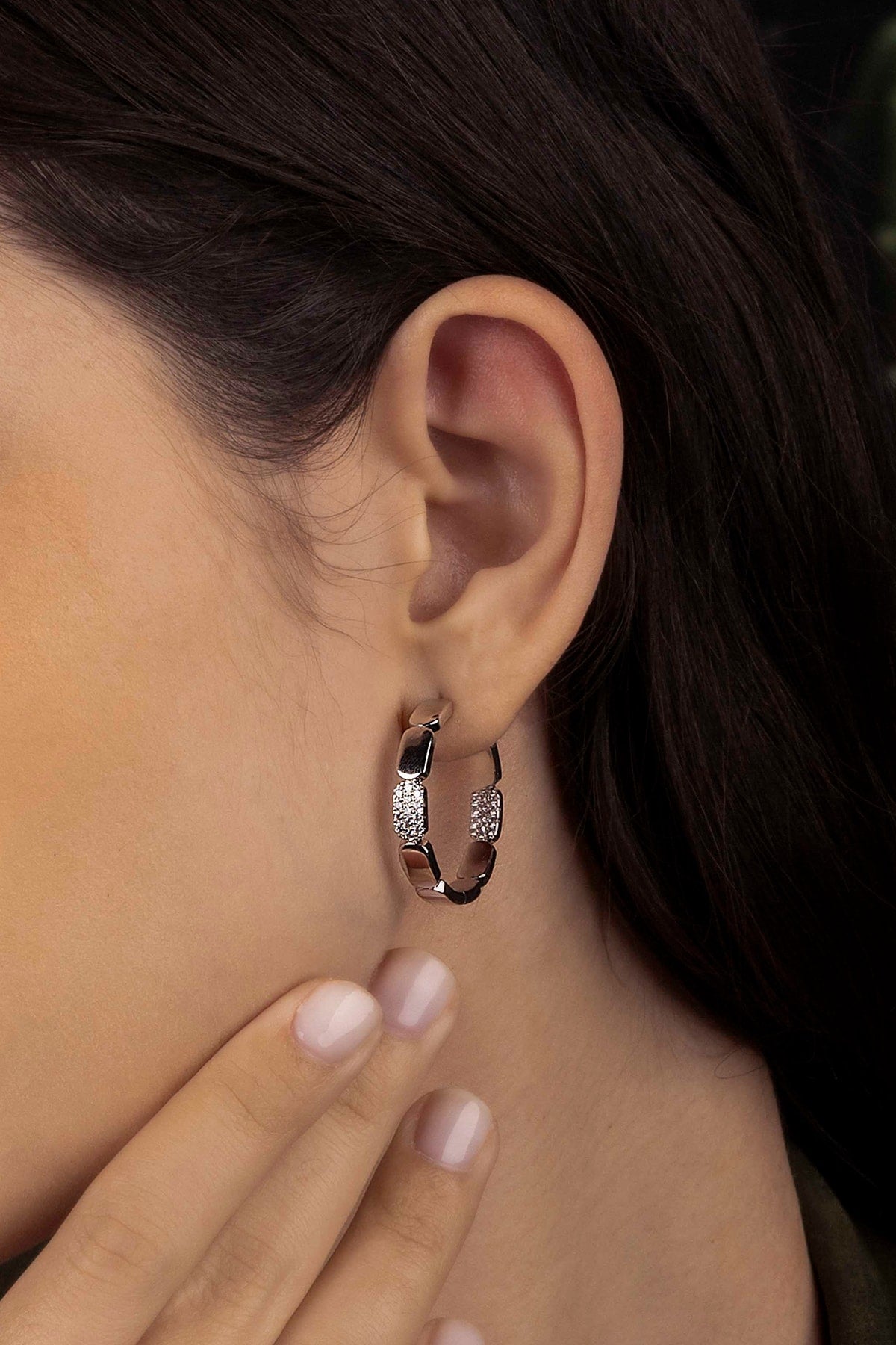 Close-up of an ear wearing a silver hoop earring