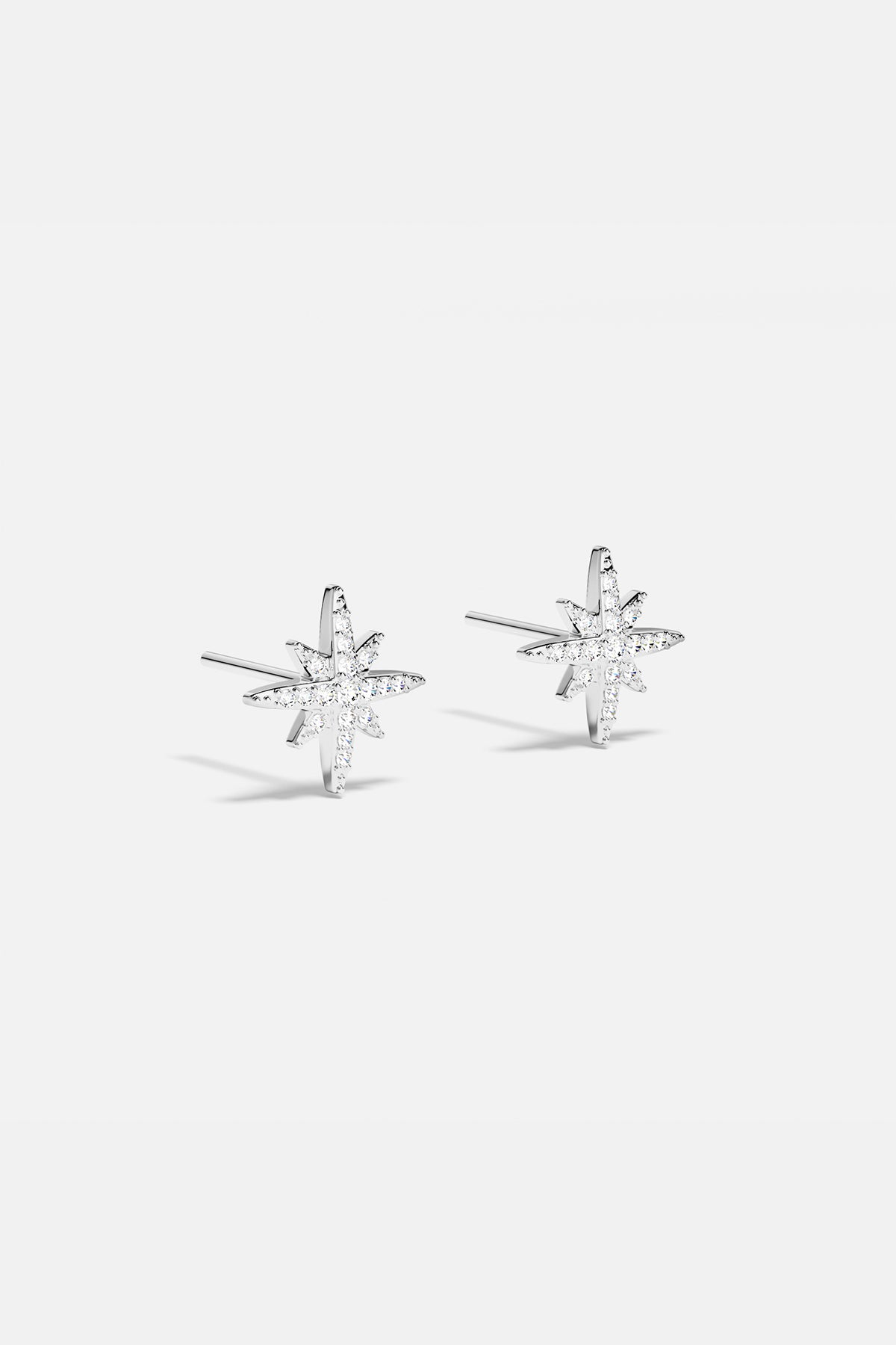 Earrings APM Monaco: silver starburst stud earrings with white stones.