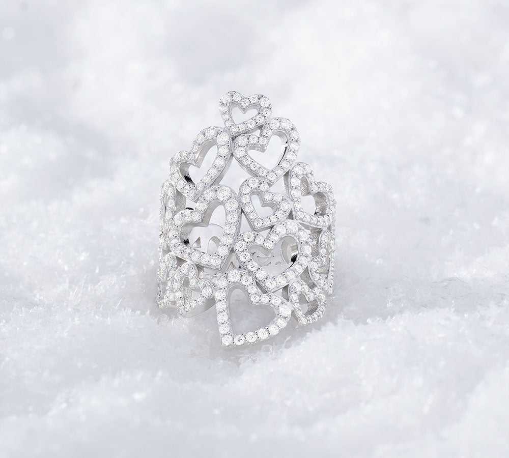 APM MONACO silver ring with heart designs on a white background