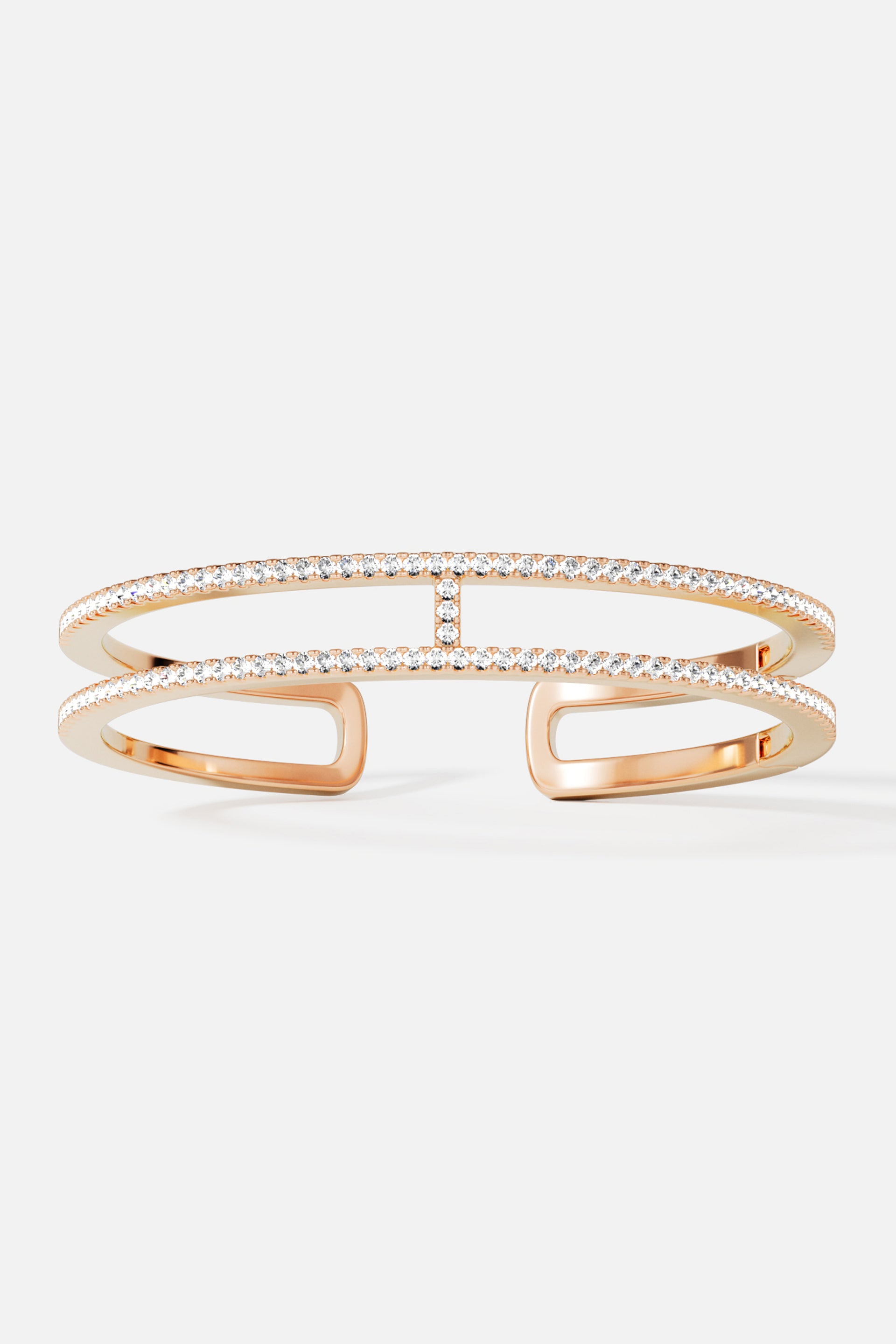 Bracelets APM Monaco, yellow gold-tone double-line pavé cuff bracelet with diamonds.
