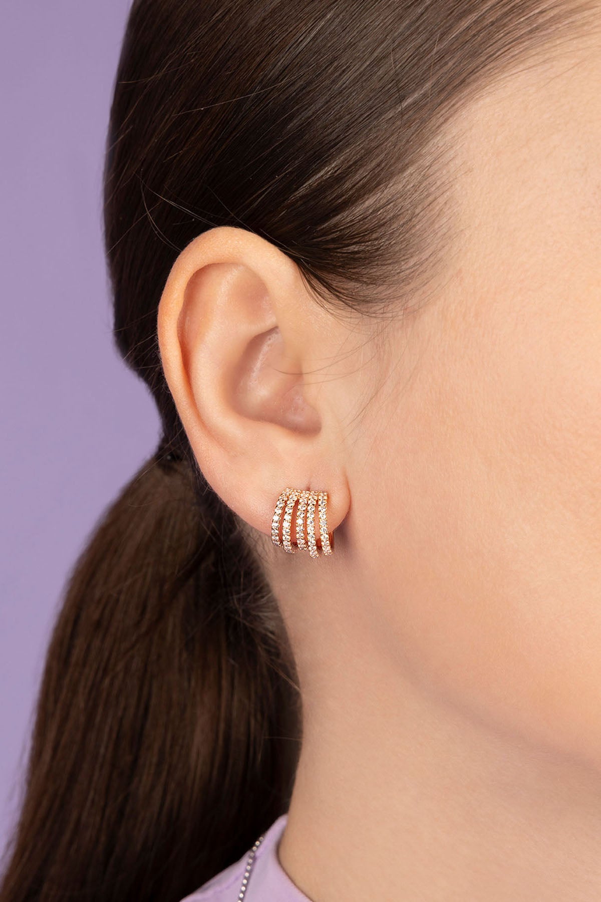 APM Monaco Rose Gold Five hoop Earring worn on model with lilac background