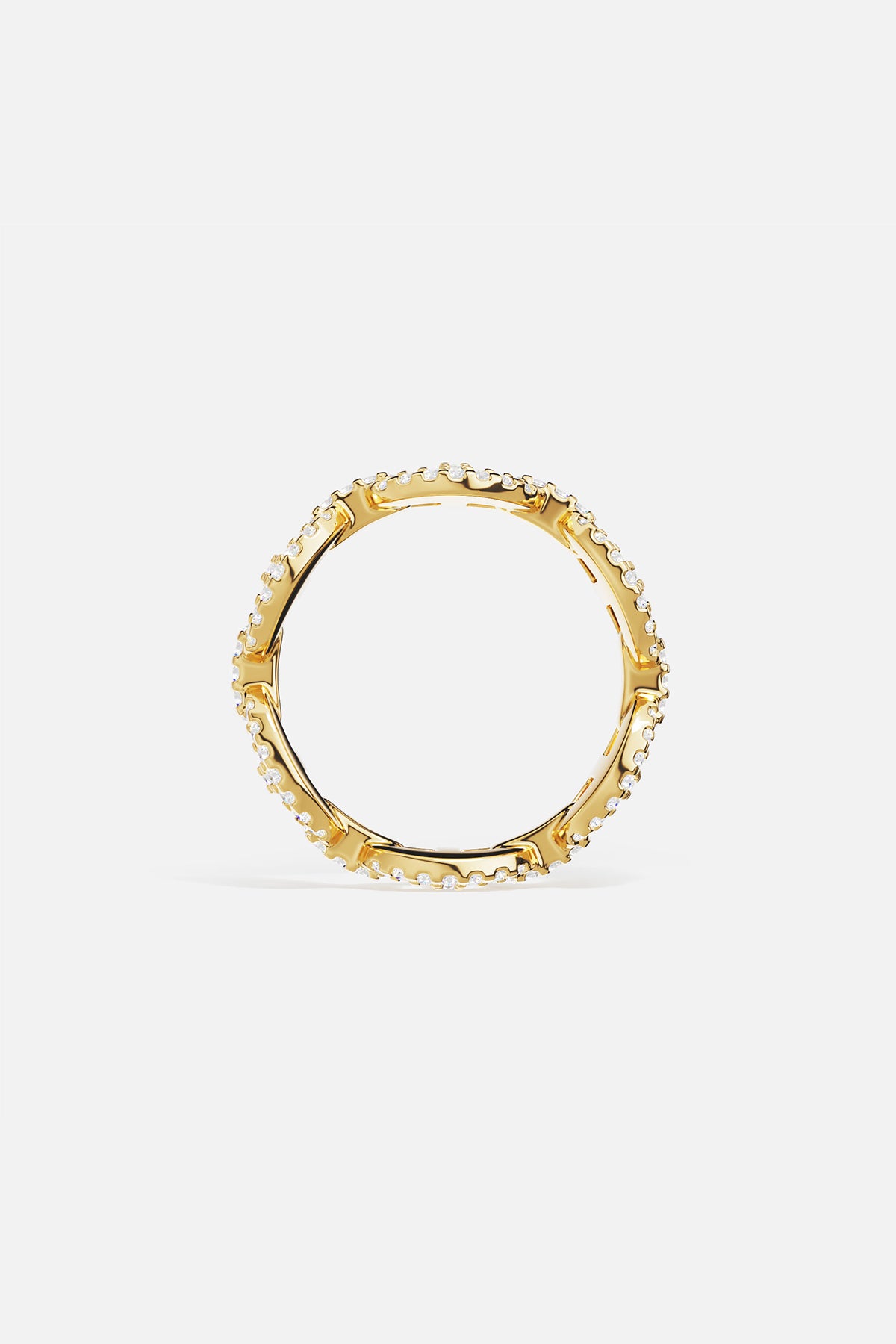 Gold ring with white cubic zirconia accents on a light gray background