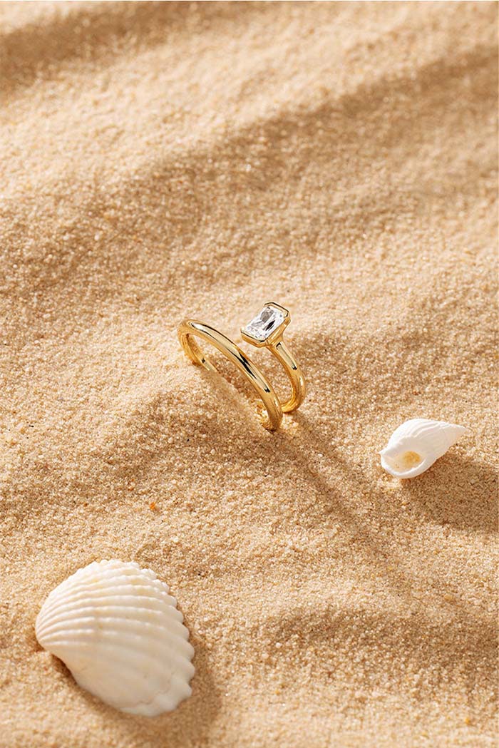 APM Monaco Twist Éclat Ring in Yellow Gold on soft beach