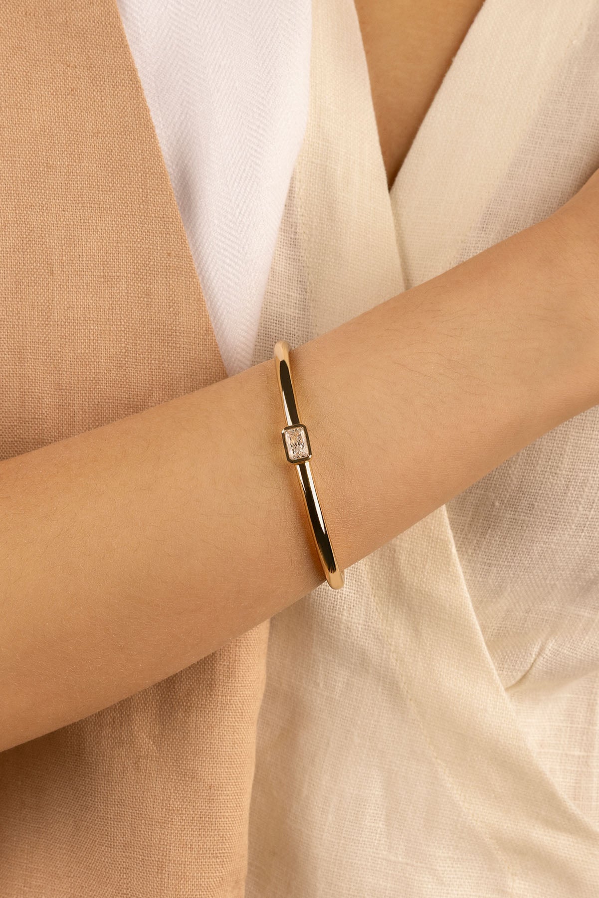 Bracelets APM Monaco yellow gold cuff bracelet with a central diamond.