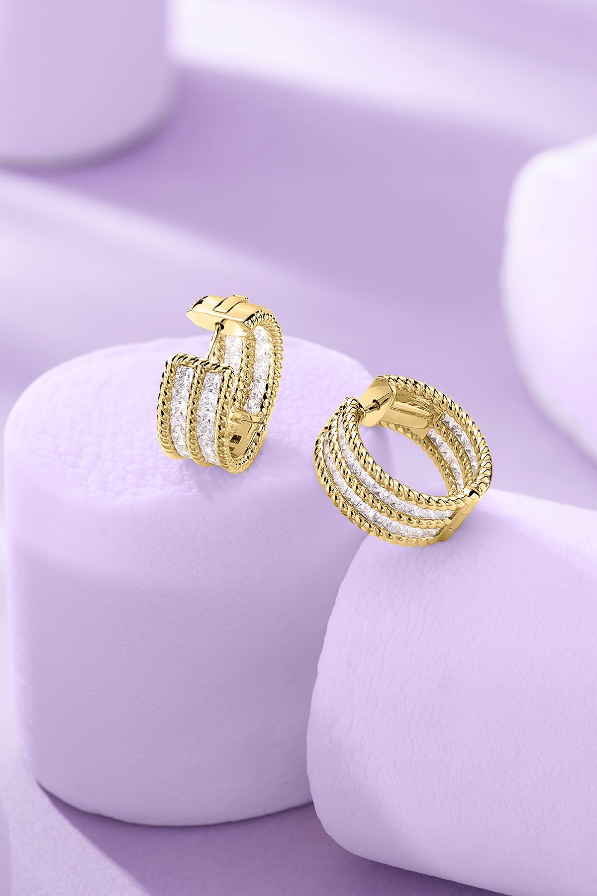 Torsade Pavé Hoop Earrings on a purple background
