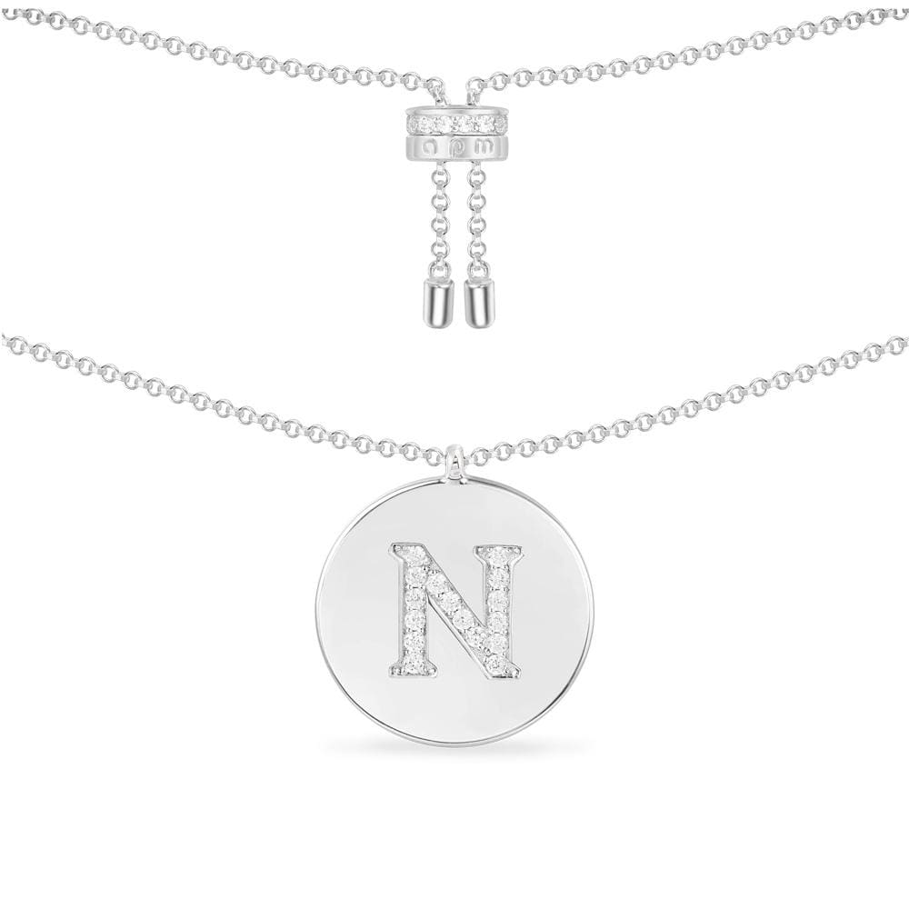 Necklaces APM Monaco. Silver-tone chain necklace with a circular pendant featuring a pavé-diamond letter N.