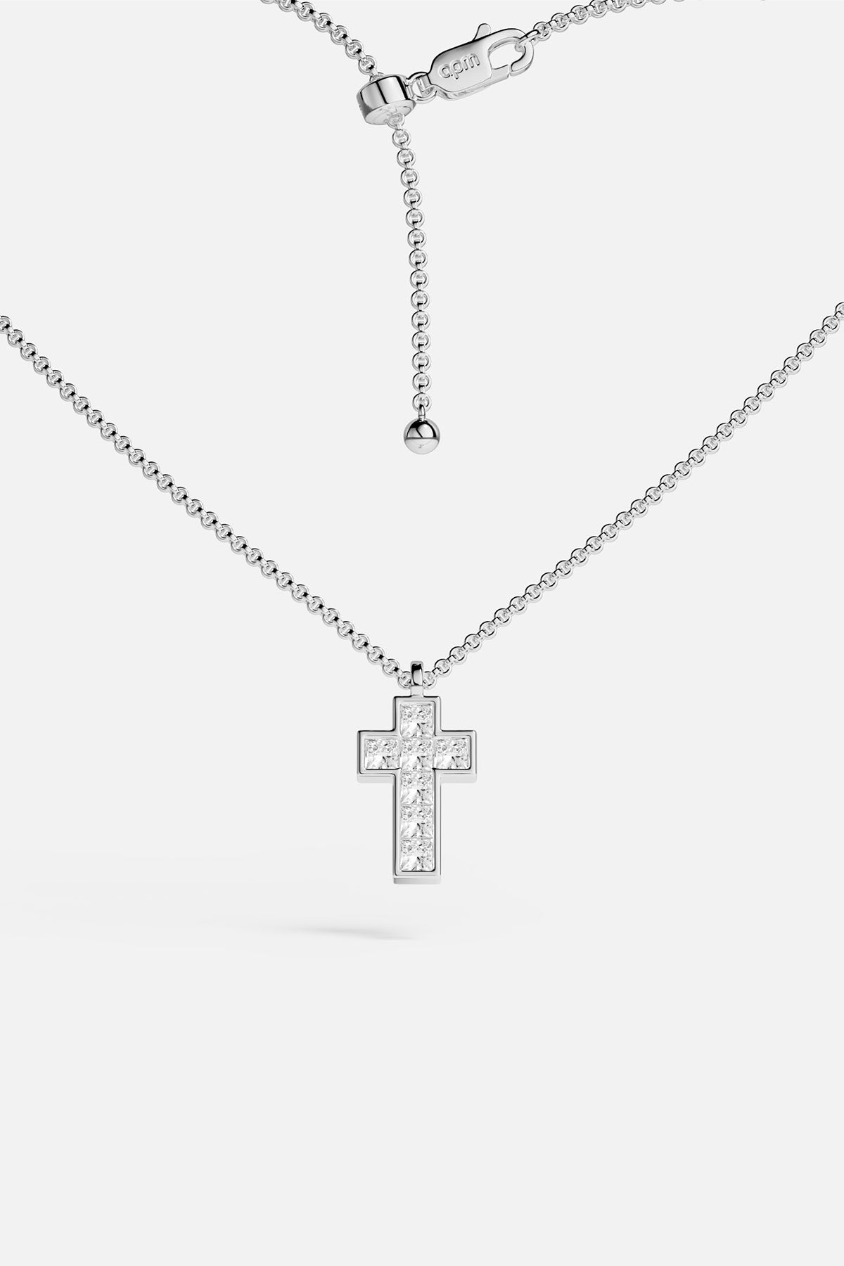 APM Cross Necklace, a luminous rhodium finish icon of quiet devotion.