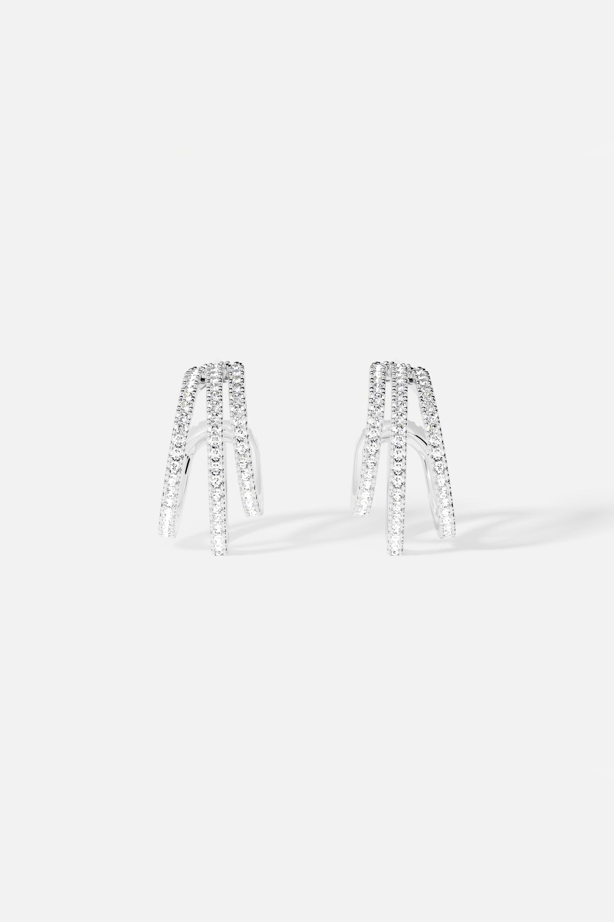 APM Earrings in rhodium finish, triple arches shimmering with modern elegance.