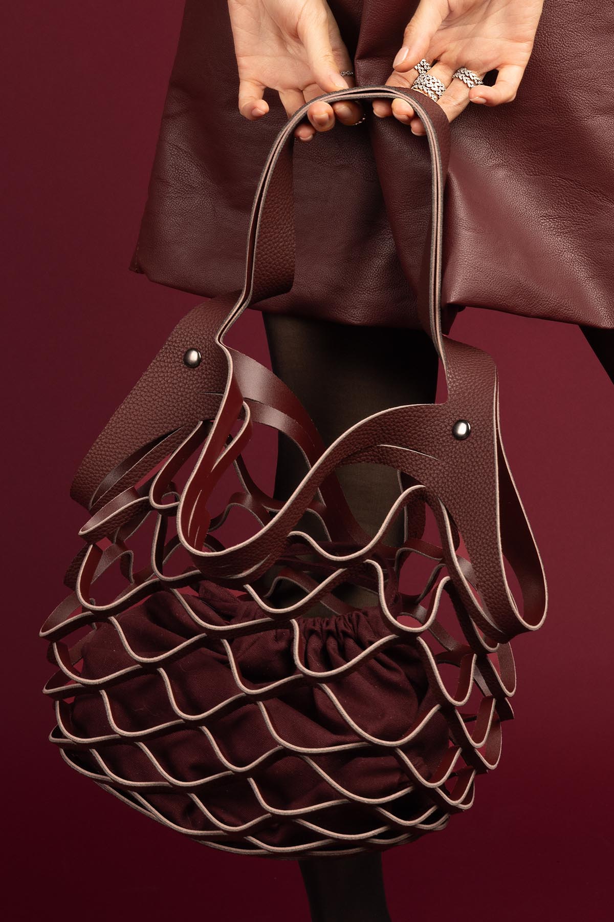 Woman wearing APM textured rings, a bold burgundy moment with quiet confidence.