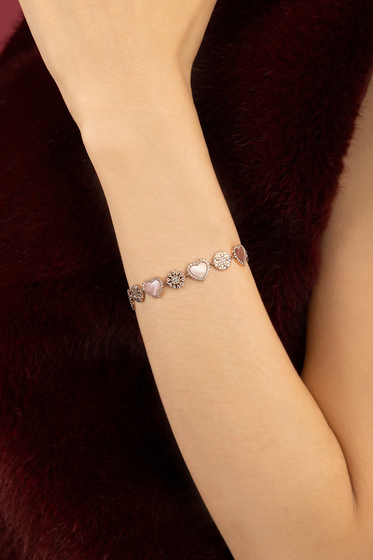 Woman wearing APM Monaco bracelet, a delicate romance in soft rosy hues.