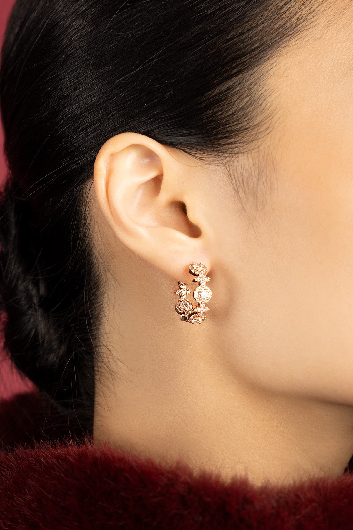 Woman wearing APM hoop earrings, a rose-hued glow of quiet elegance.