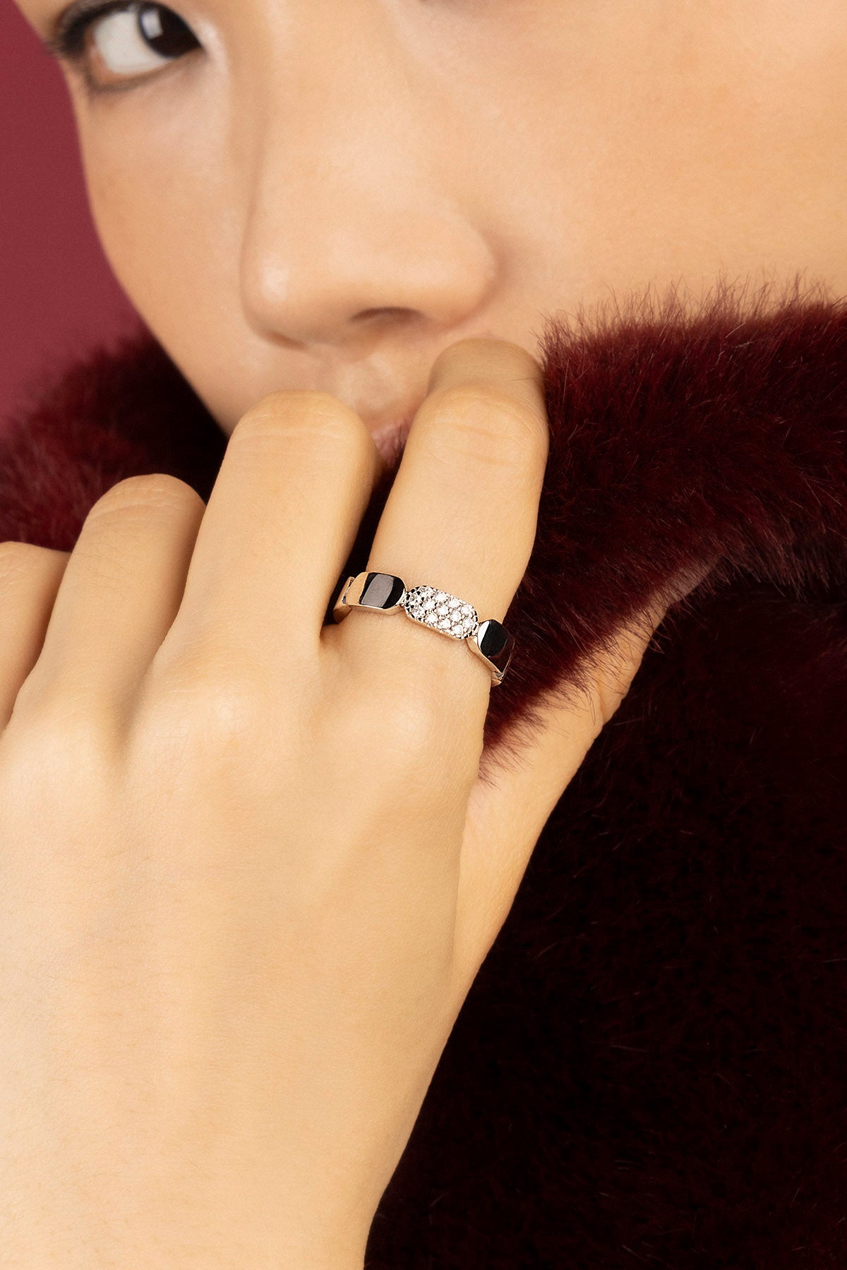 Woman wearing APM Morse Ring, a whisper of modern elegance against soft fur.