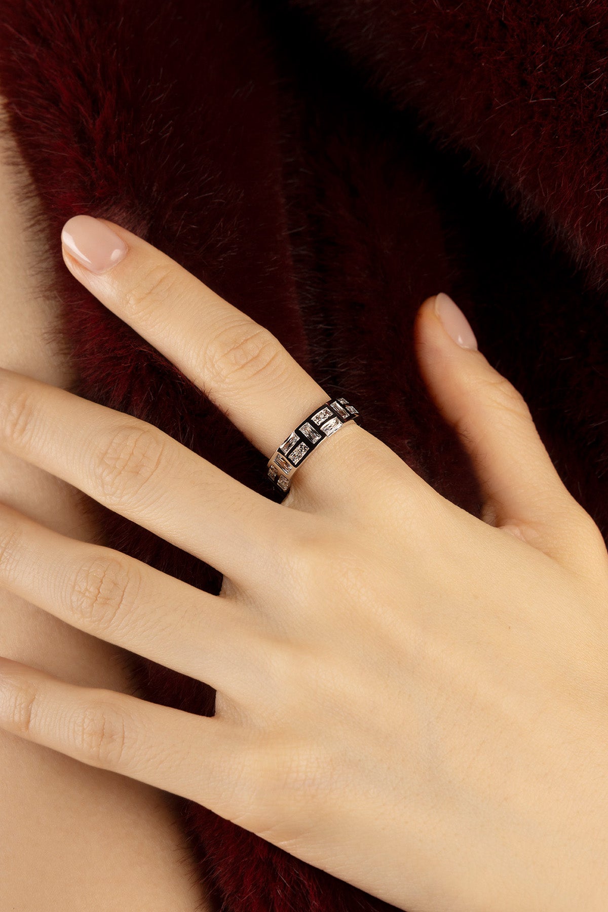 Woman wearing APM ring, a quiet sparkle against soft winter warmth.