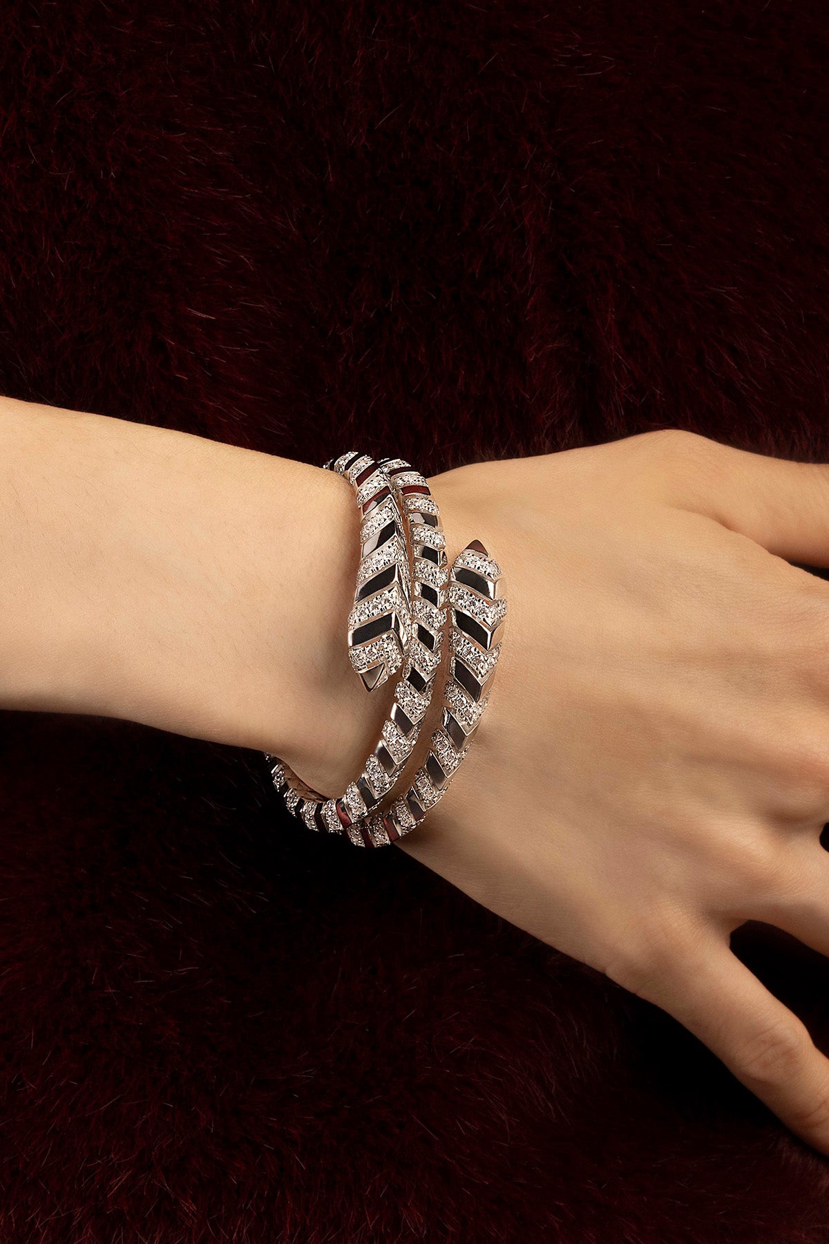 Woman wearing APM feather bracelet, wrapped elegance with a shimmering, weightless allure.