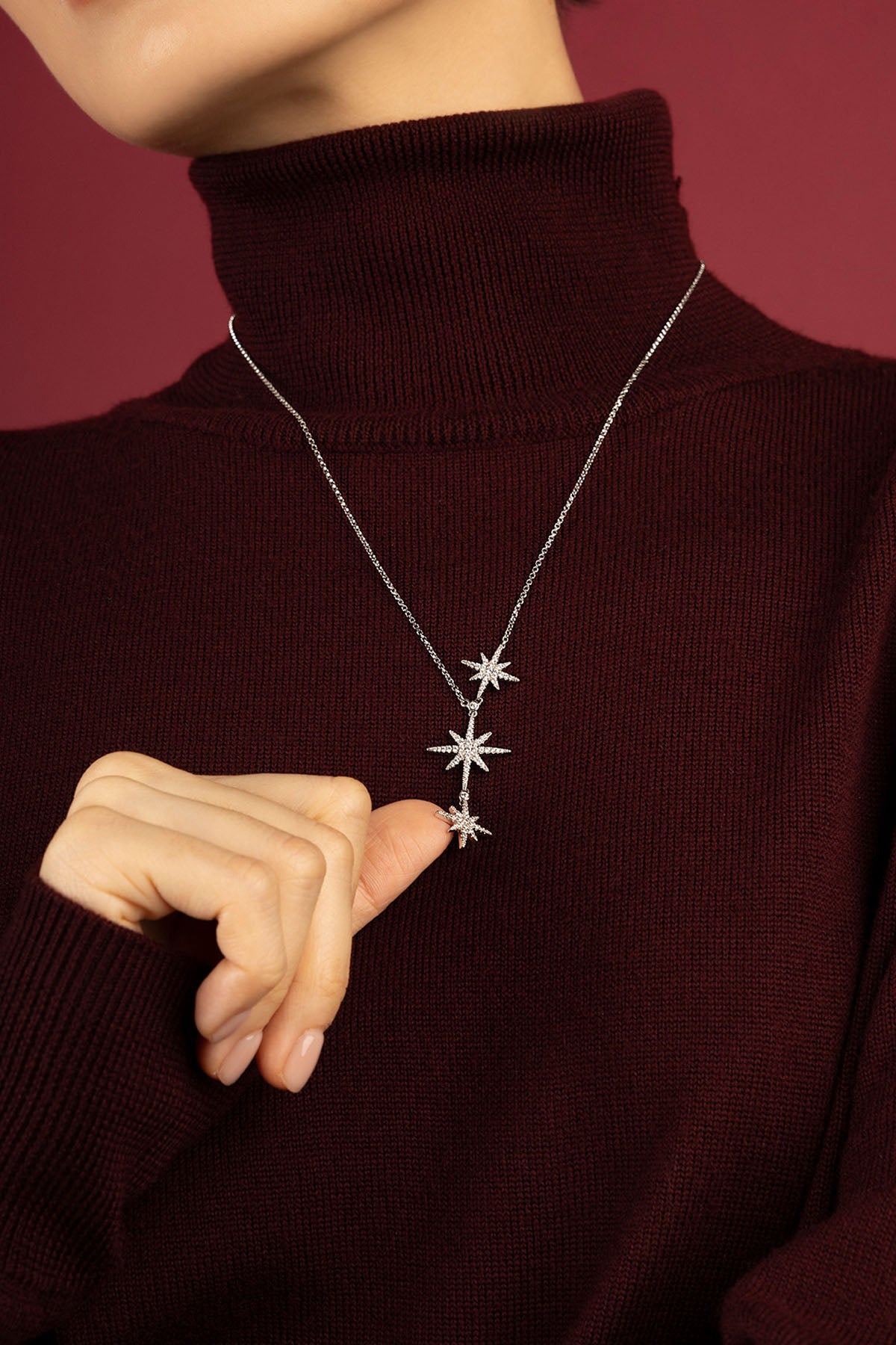 Woman wearing APM Météorites Necklace, a cascade of stars lighting winter's warmth.