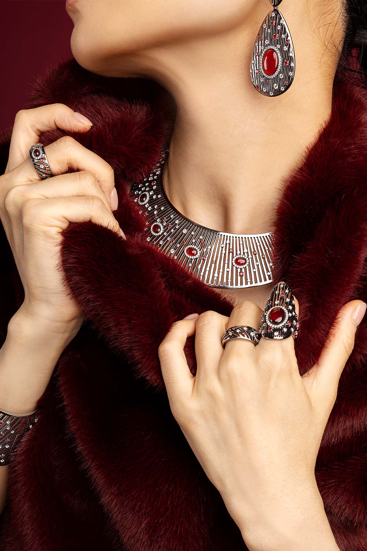 Woman wearing APM Monaco statement set, crimson allure meets rhodium finish in bold elegance.