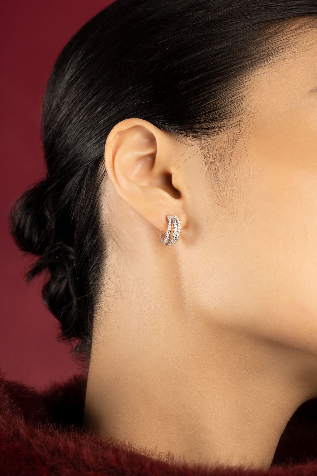 Woman wearing APM hoop earrings, a shimmering whisper of modern elegance.