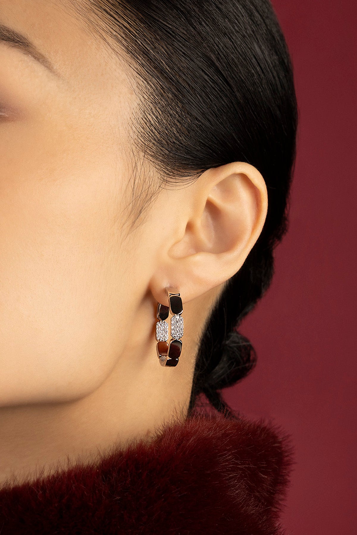 Woman wearing APM Monaco hoop earrings, a bold whisper of modern elegance.