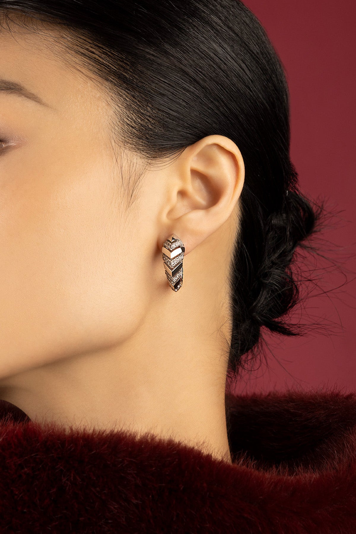 Woman wearing APM chevron hoop earrings, a bold whisper of modern elegance.