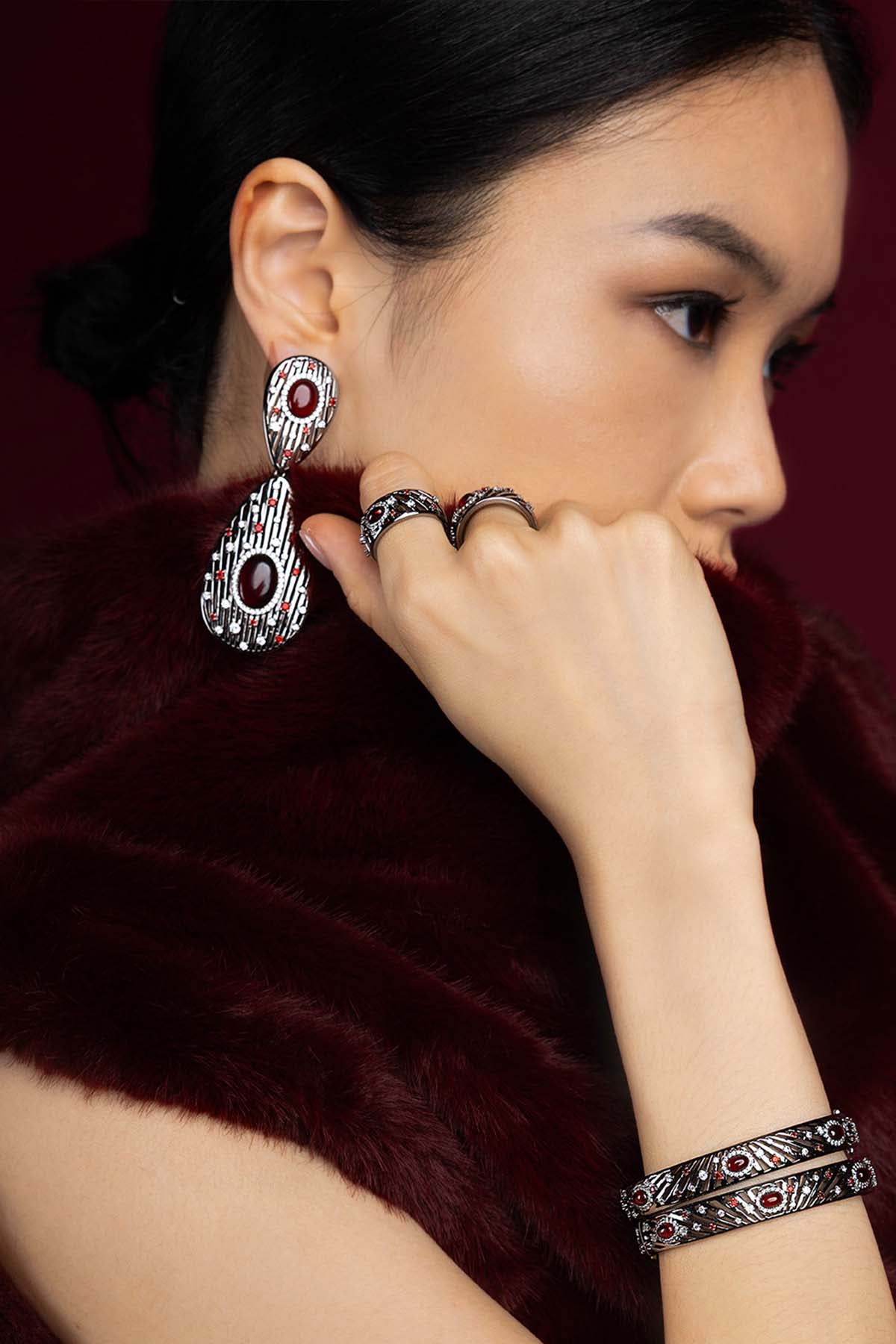 Woman wearing APM Morse Earrings, a bold statement in deep crimson allure.