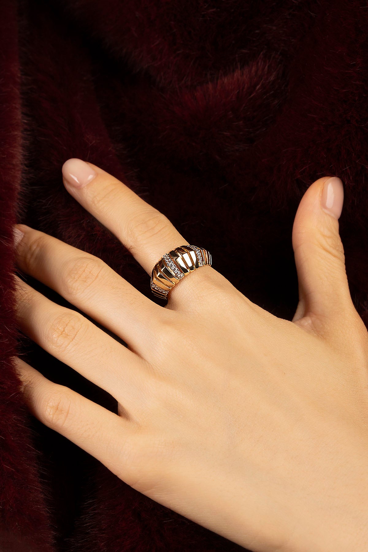 Woman wearing APM ring, a golden statement of quiet winter allure.