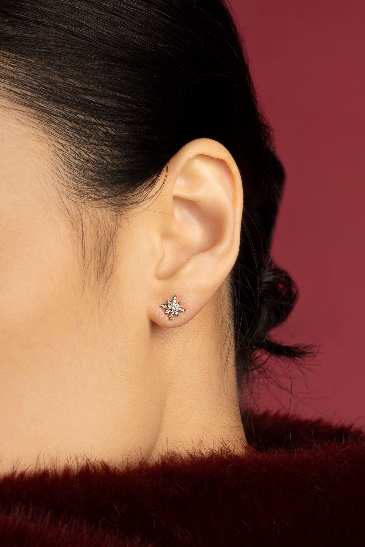 Woman wearing APM star stud earring, a quiet spark of celestial charm.