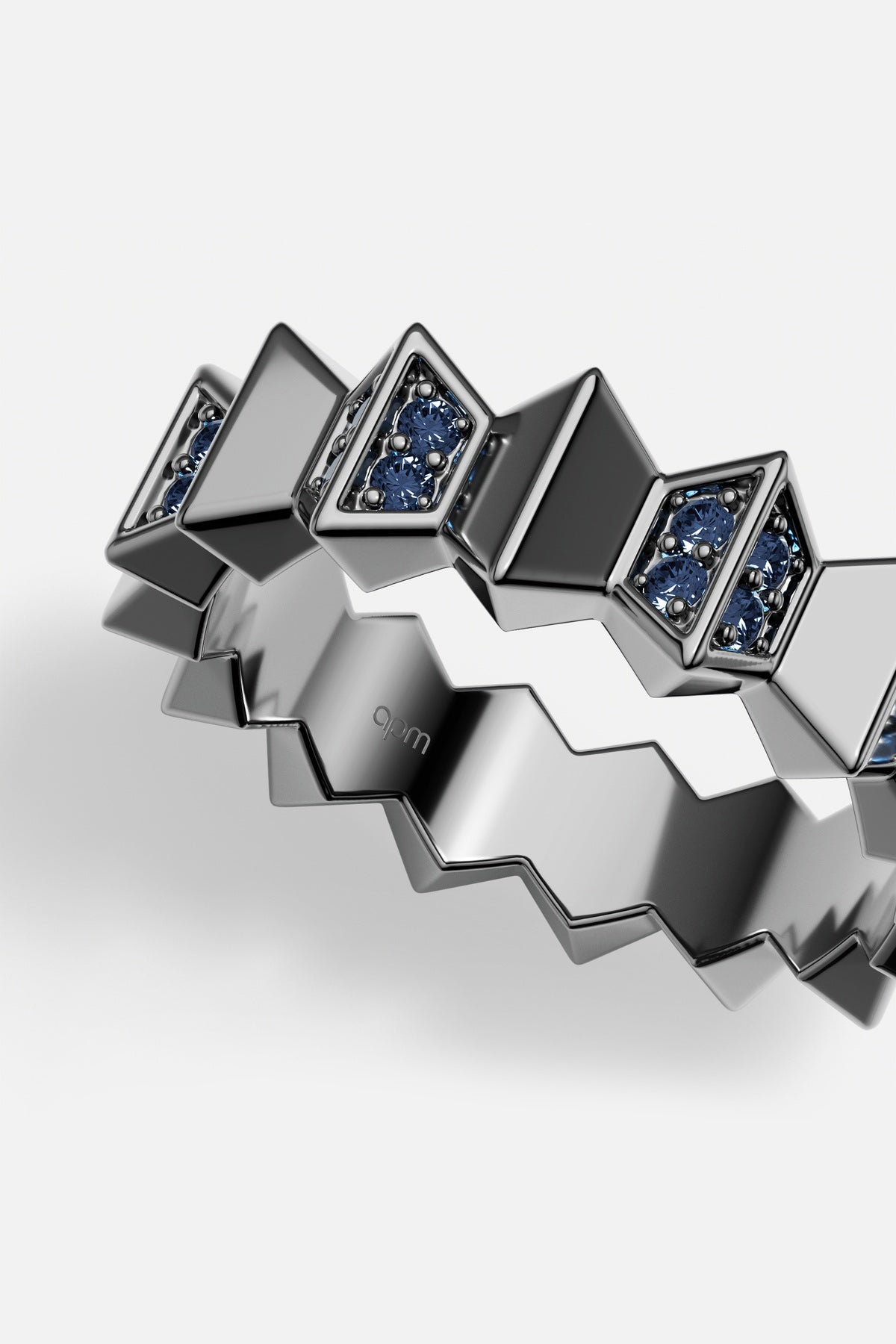 APM Ring in rhodium finish, zigzag edges and deep blue sparkle, boldly modern.