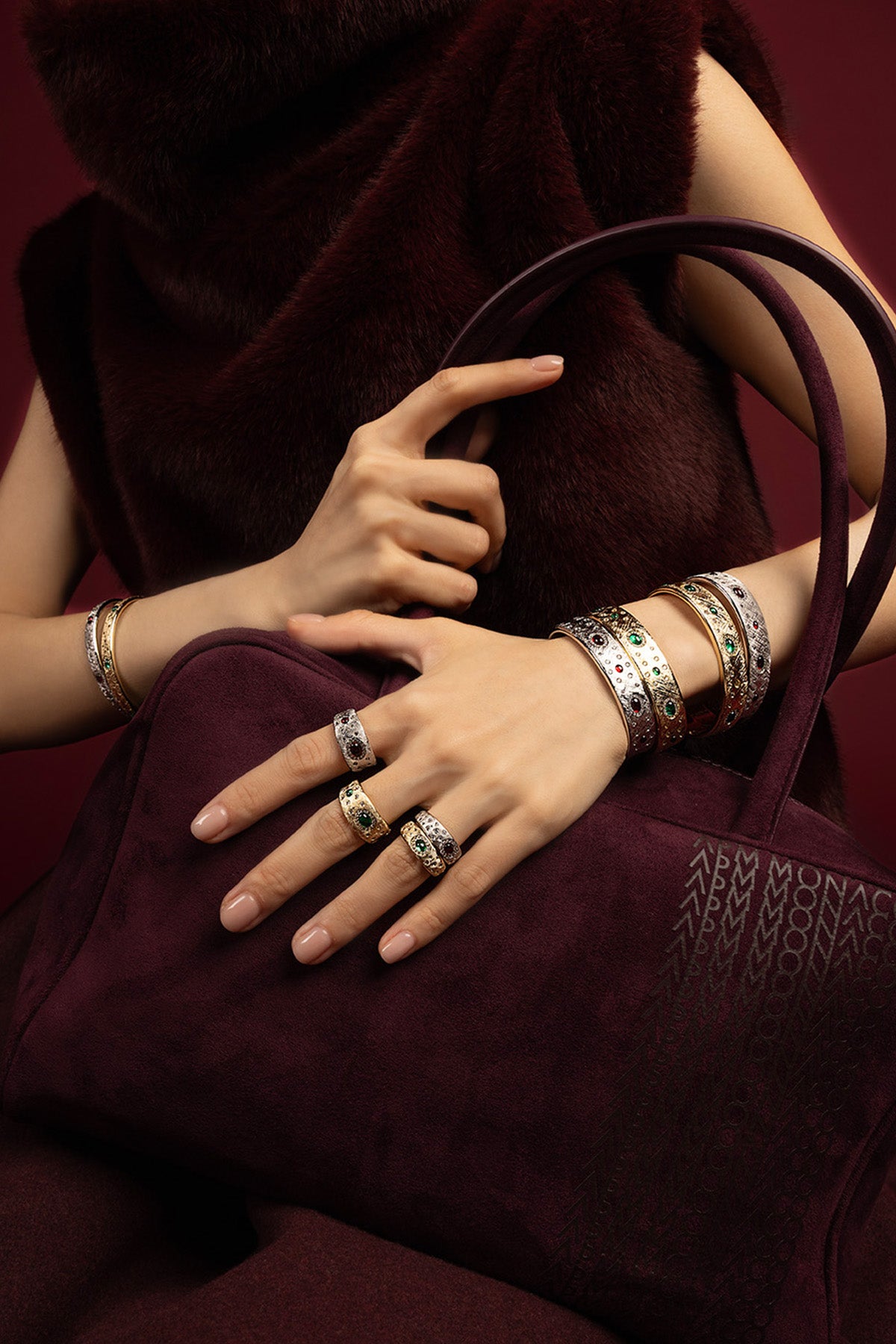 Woman wearing APM stacked bangles and rings, a rich winter statement in bloom.