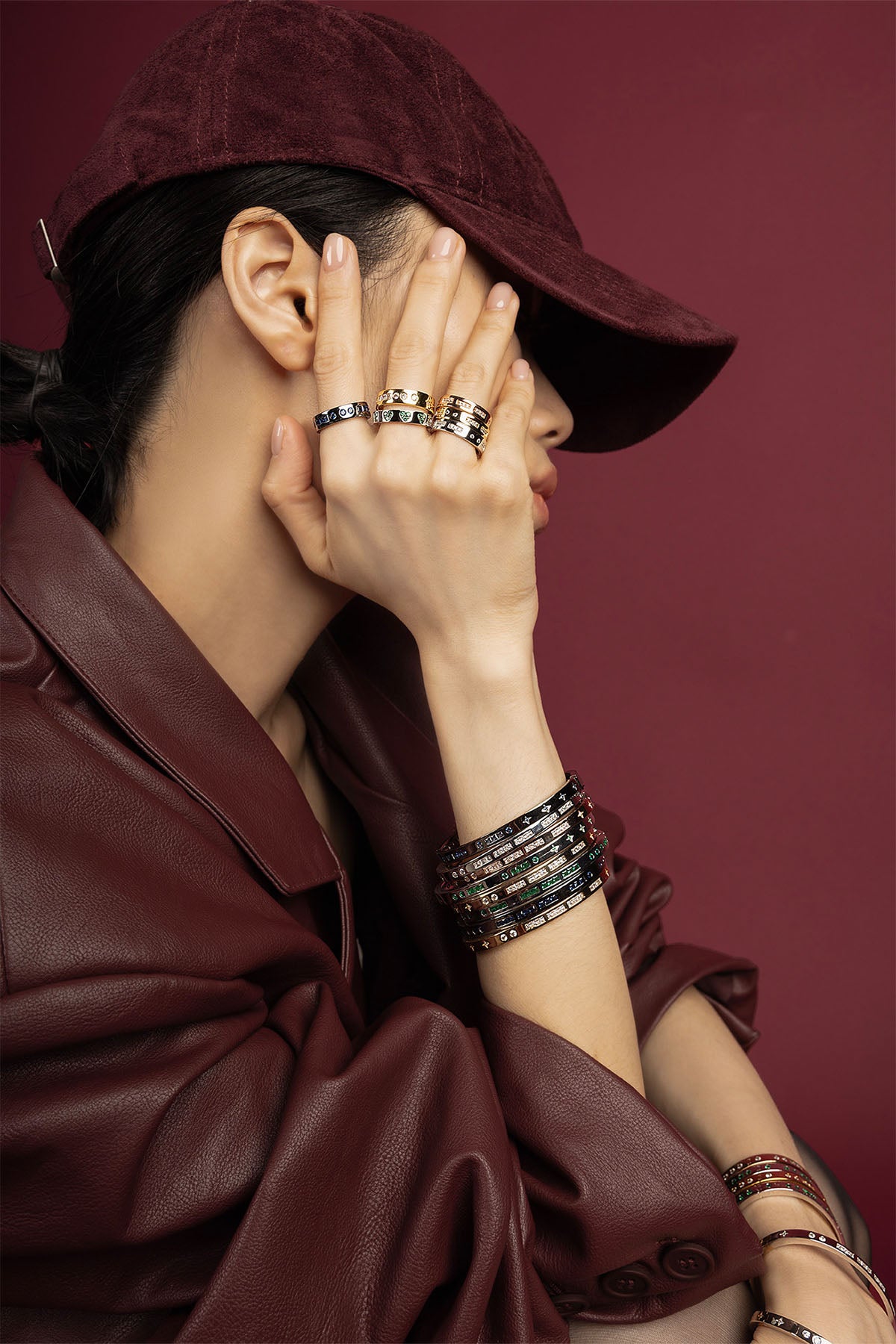 Woman wearing APM stacked rings and bangles, a bold statement in rich tones.