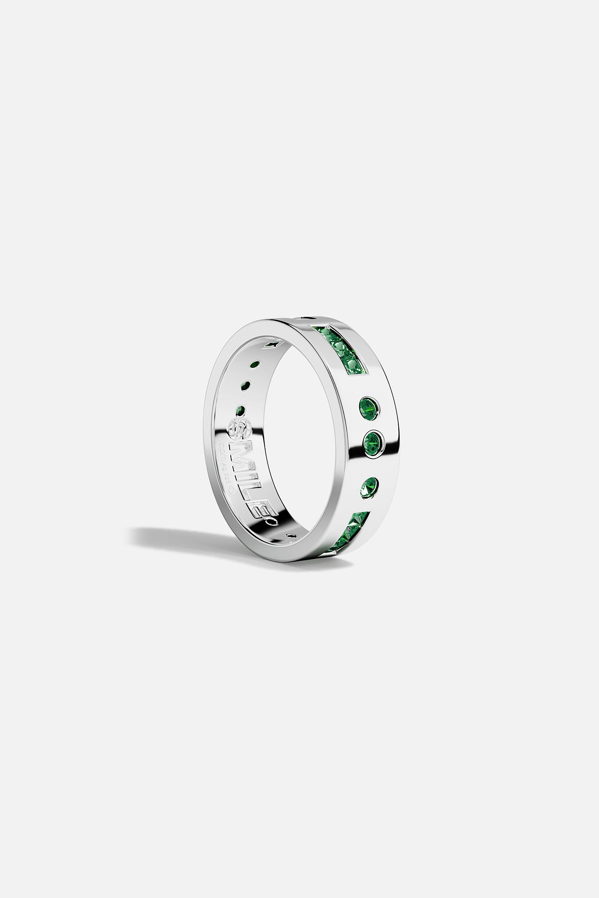 Silver ring with green stones on a white background