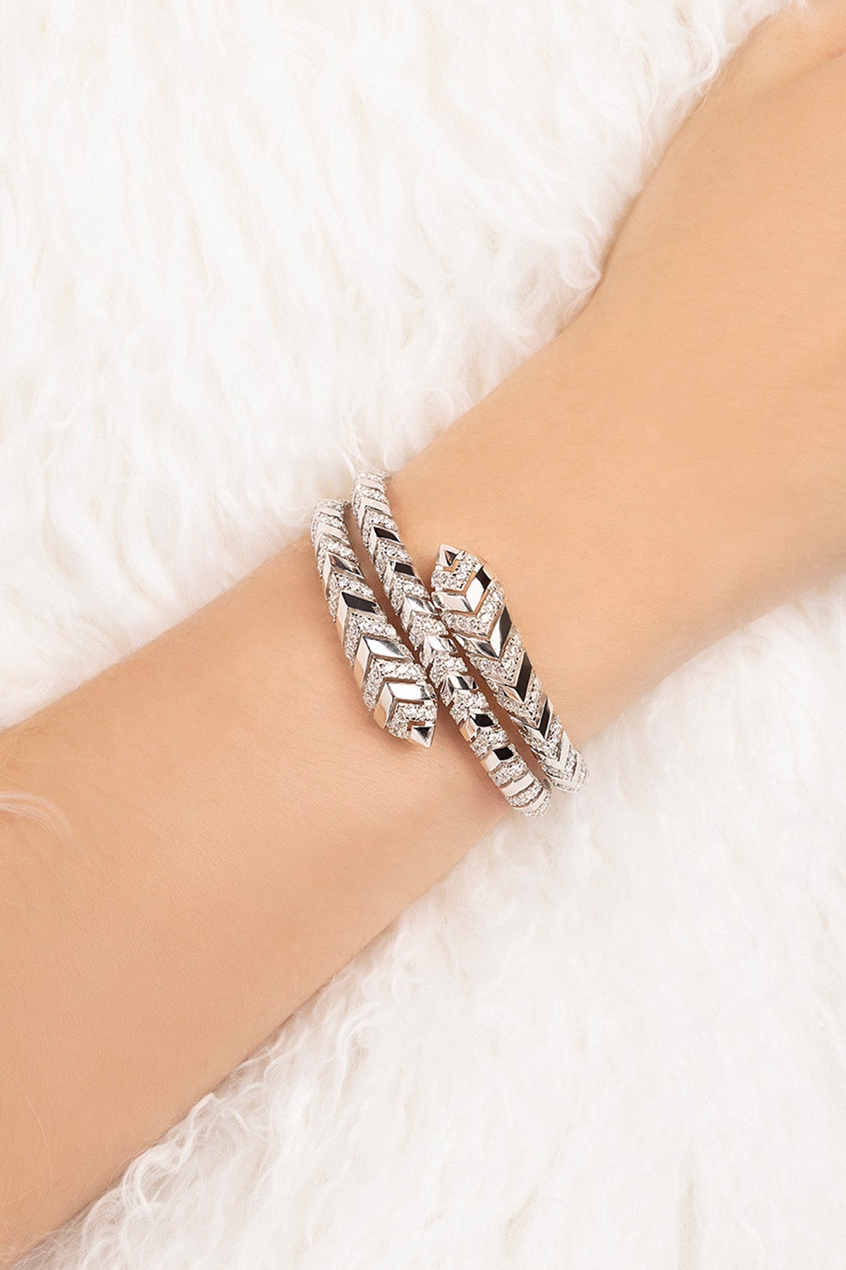 Silver bracelet on a wrist with a white textured background