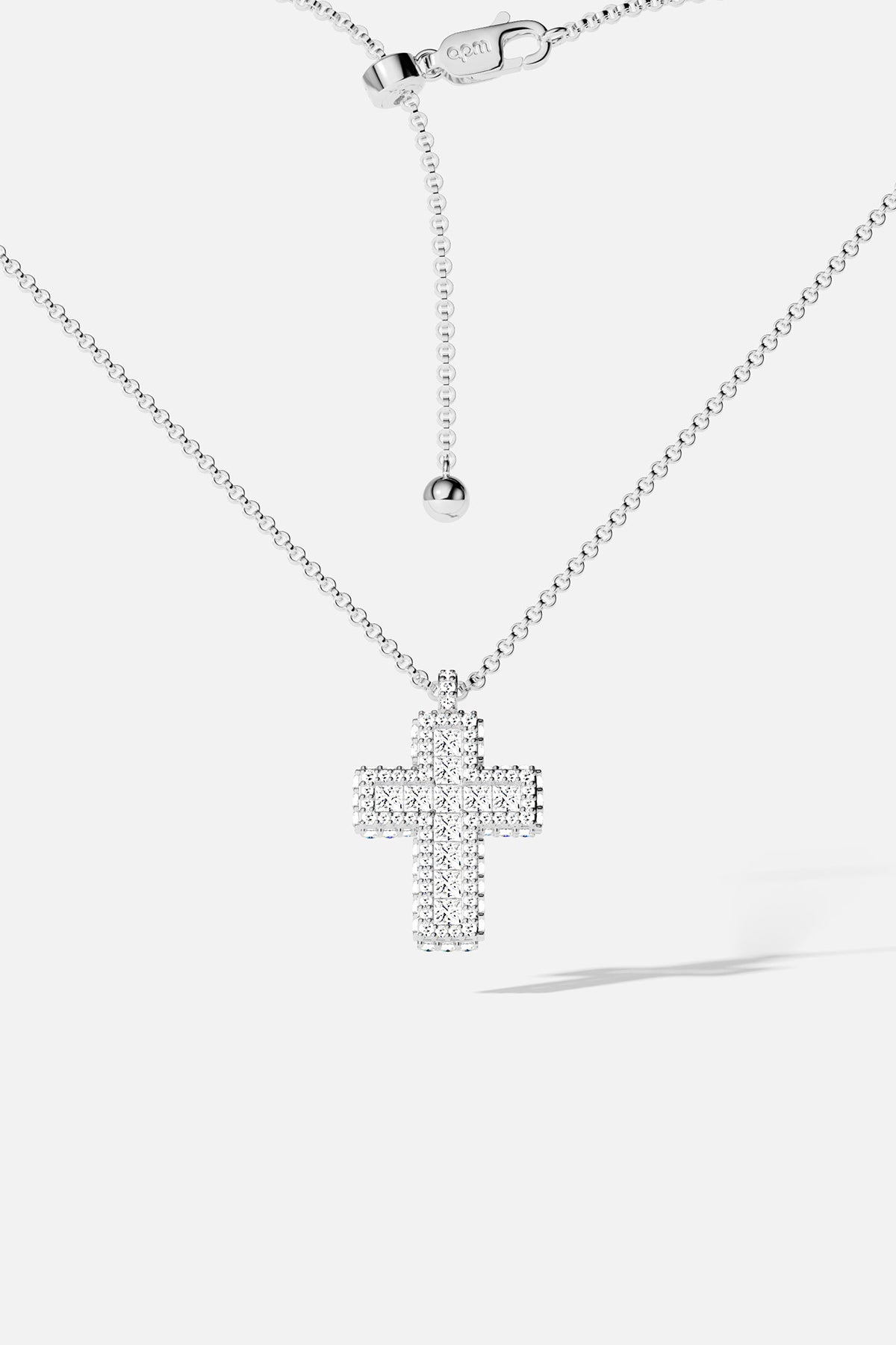 Silver cross necklace with white stones on a white background