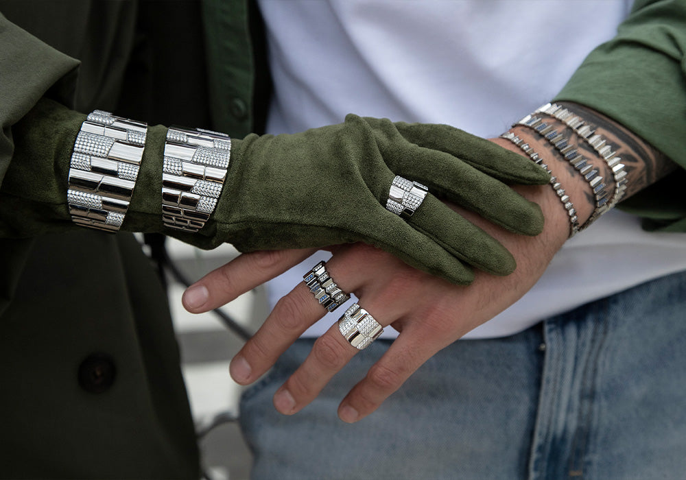 Close-up of hands wearing green gloves and apm monaco silver pave bracelets 