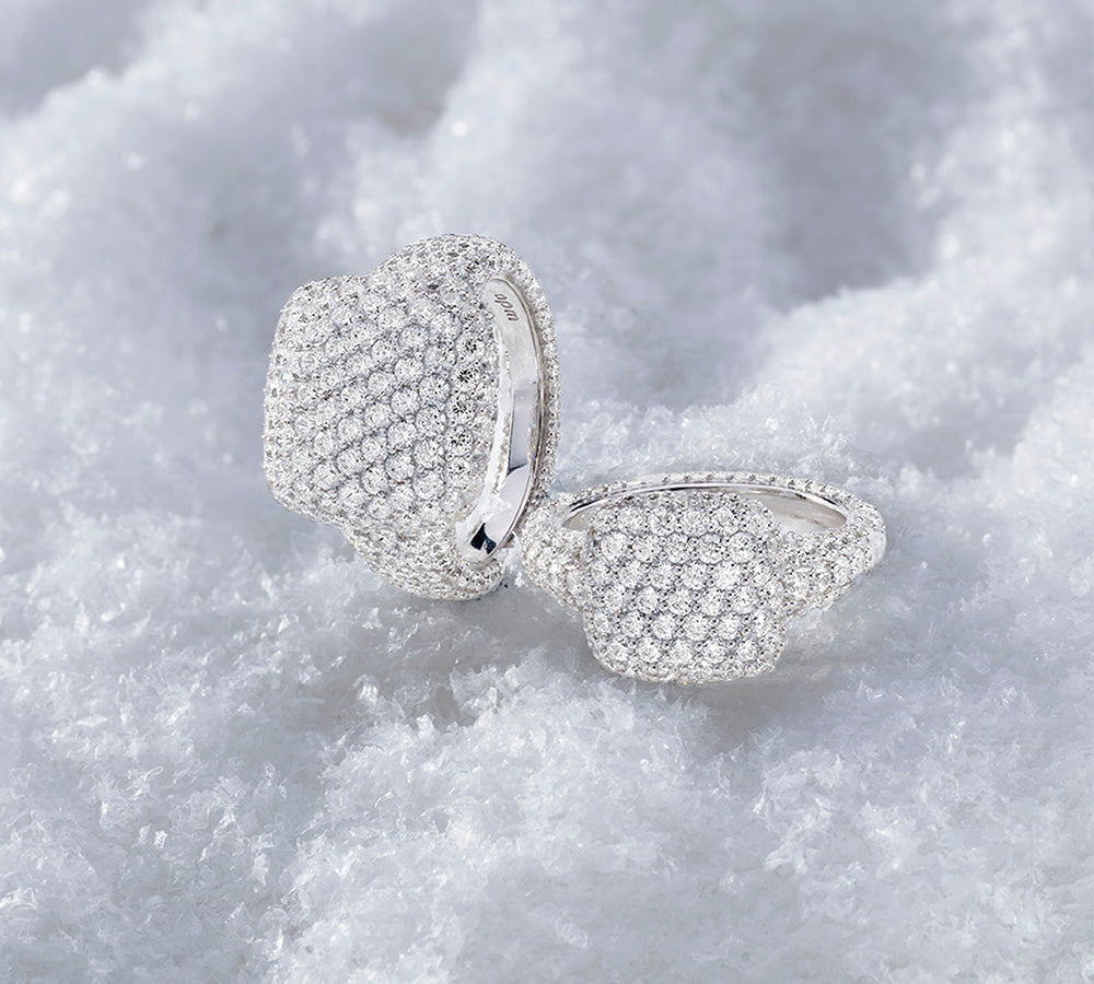 Two APM MONACO hiver pave rings in silver on a textured white surface