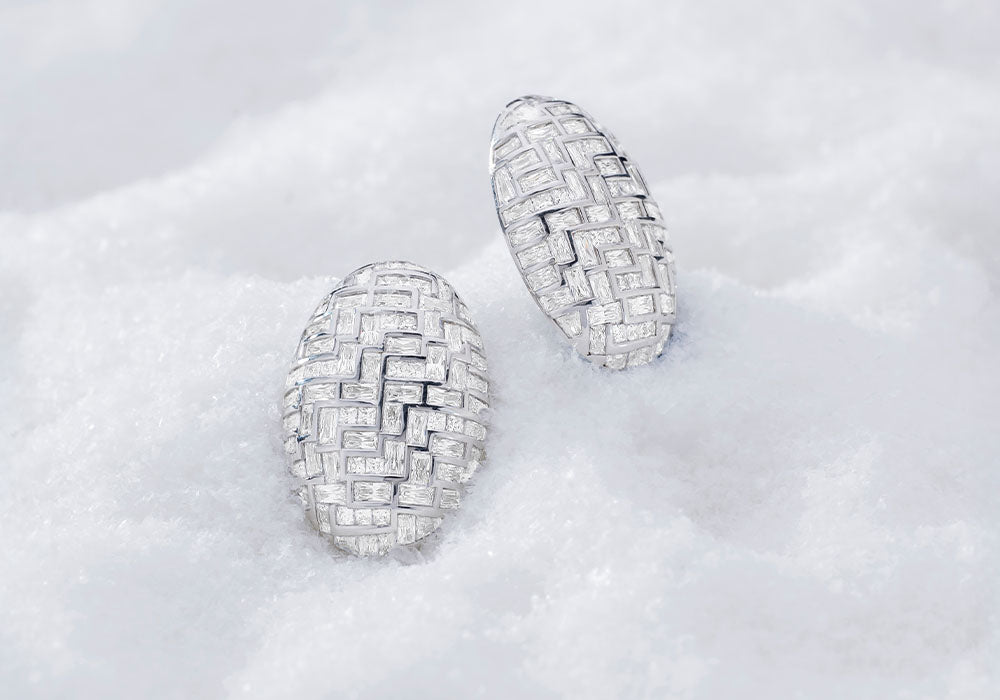 Pair of APM MONACO hiver earrings on a light gray background